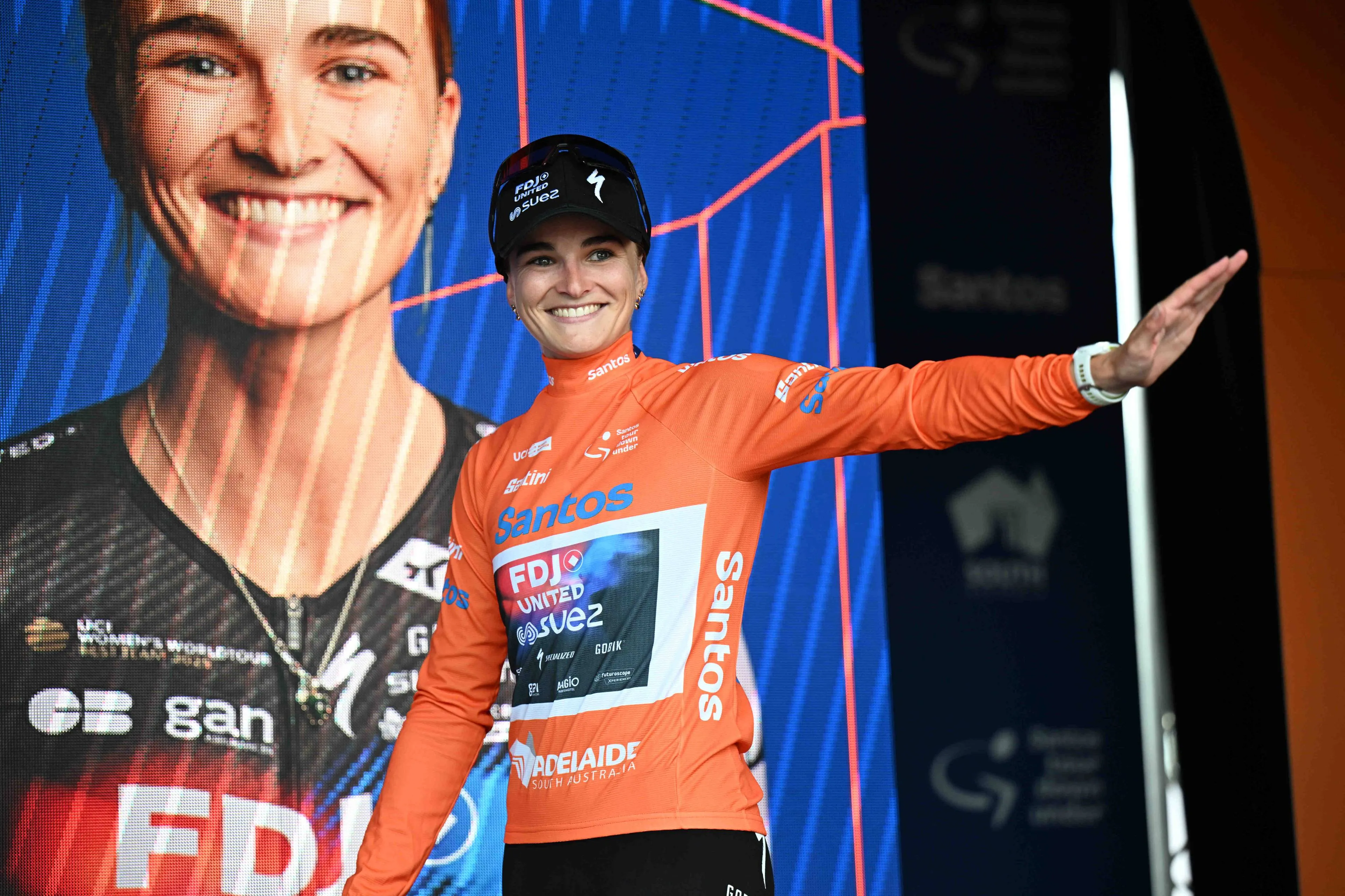 Ally Wollaston waves to fans on the podium at the 2026 Tour Down Under