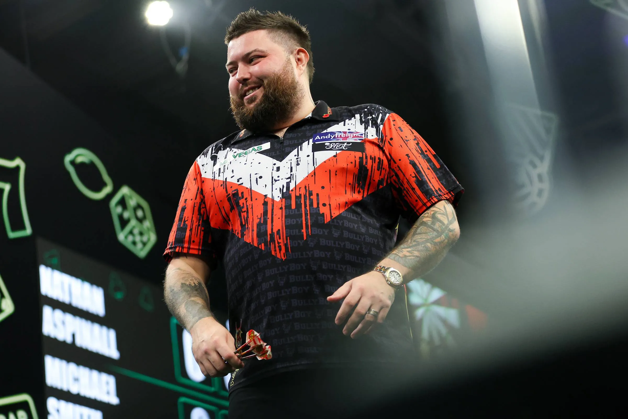 Michael Smith smiling on stage at the Grand Slam of Darts