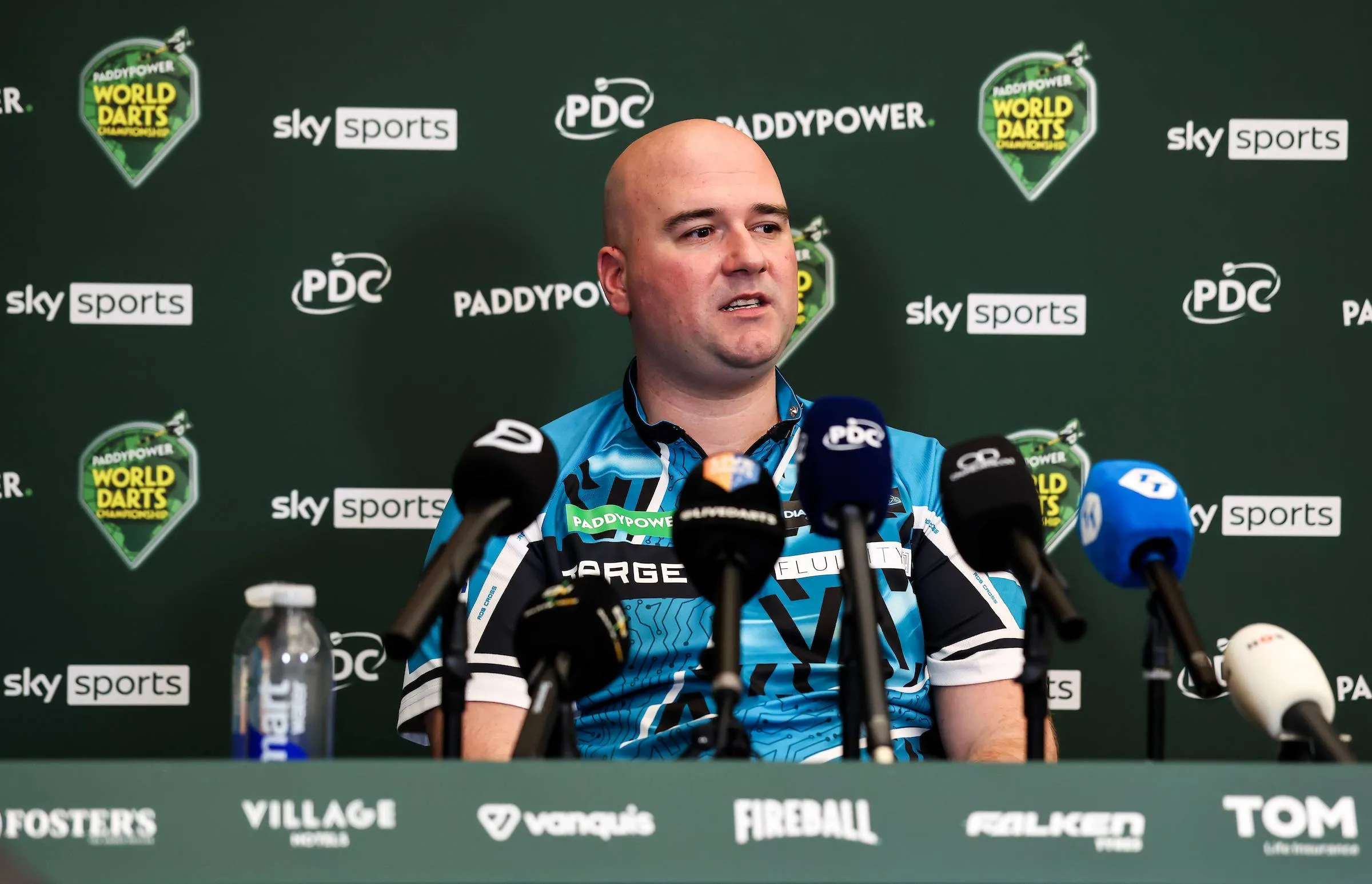Rob Cross in a press conference with a backdrop.
