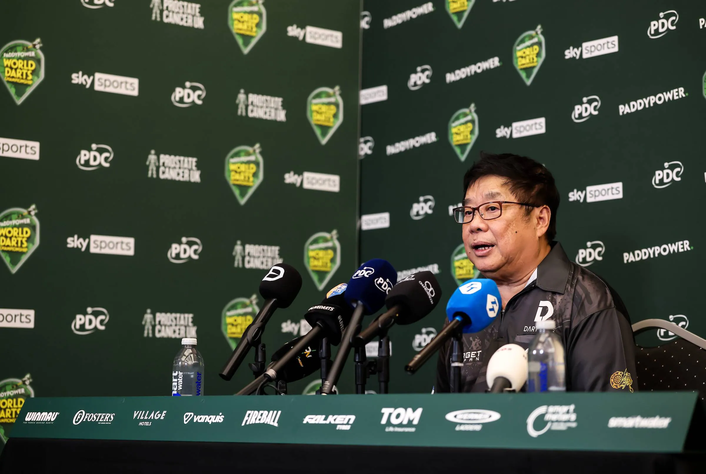 Paul Lim talks to microphones in press conference.