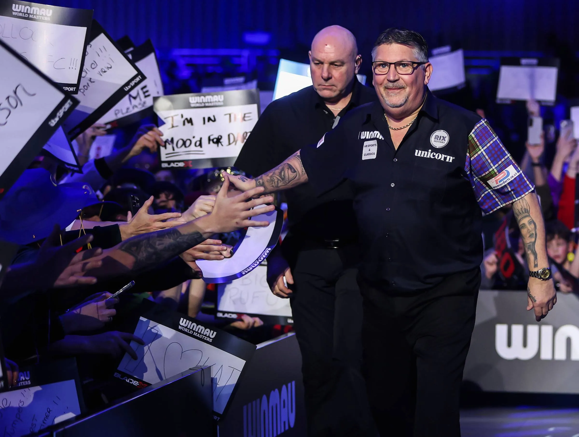 Gary Anderson touches fan hands.