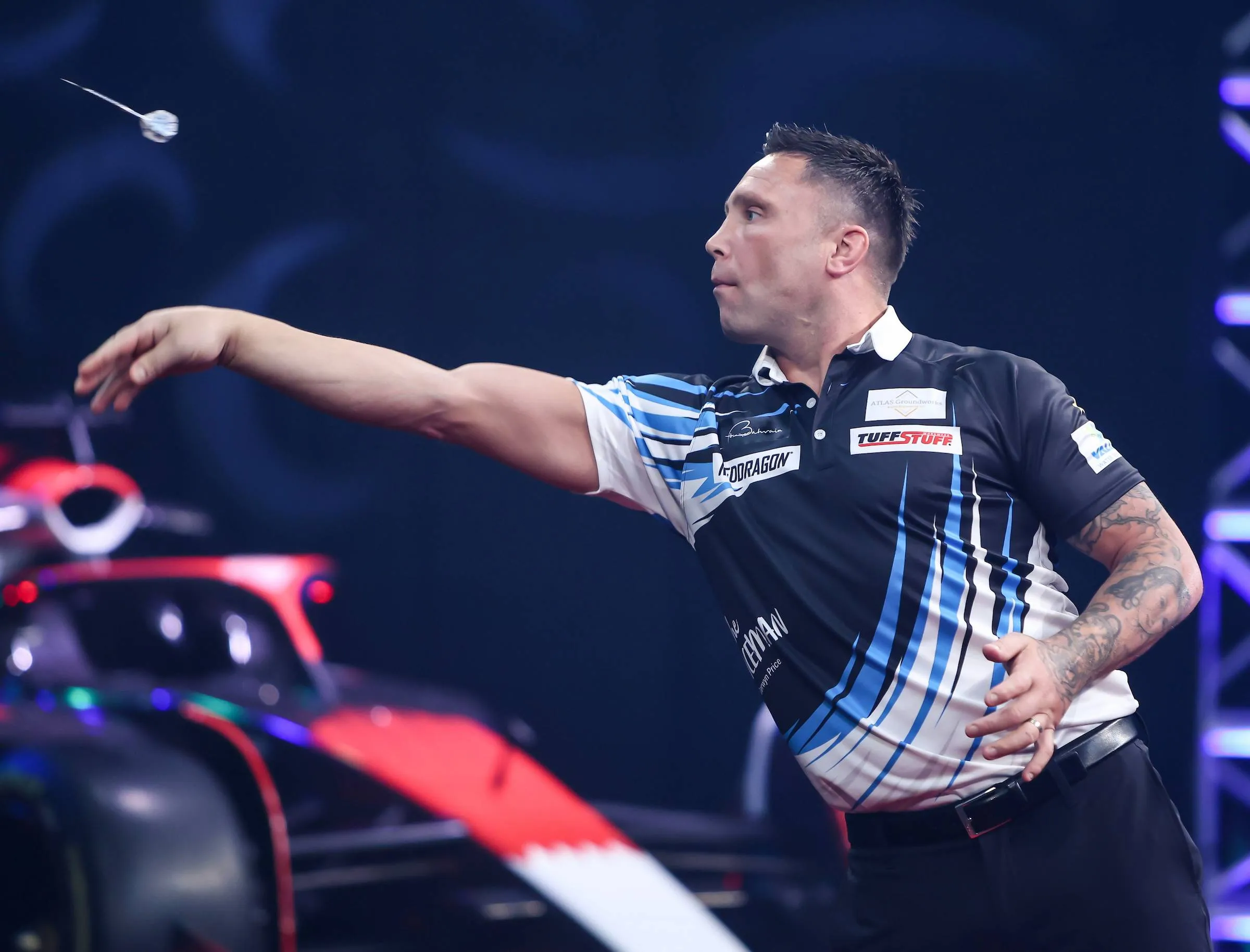 Gerwyn Price throws in front of a Formula 1 car in Bahrain