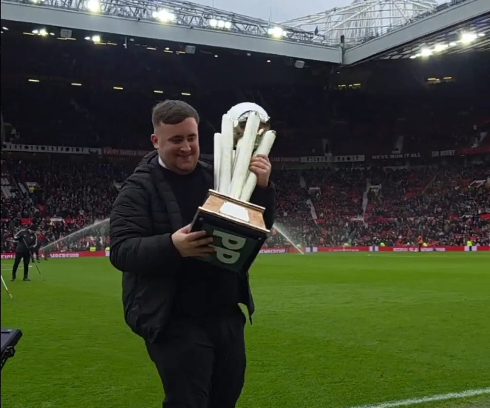 Luke Littler parades World Darts Championship trophy around Old Trafford