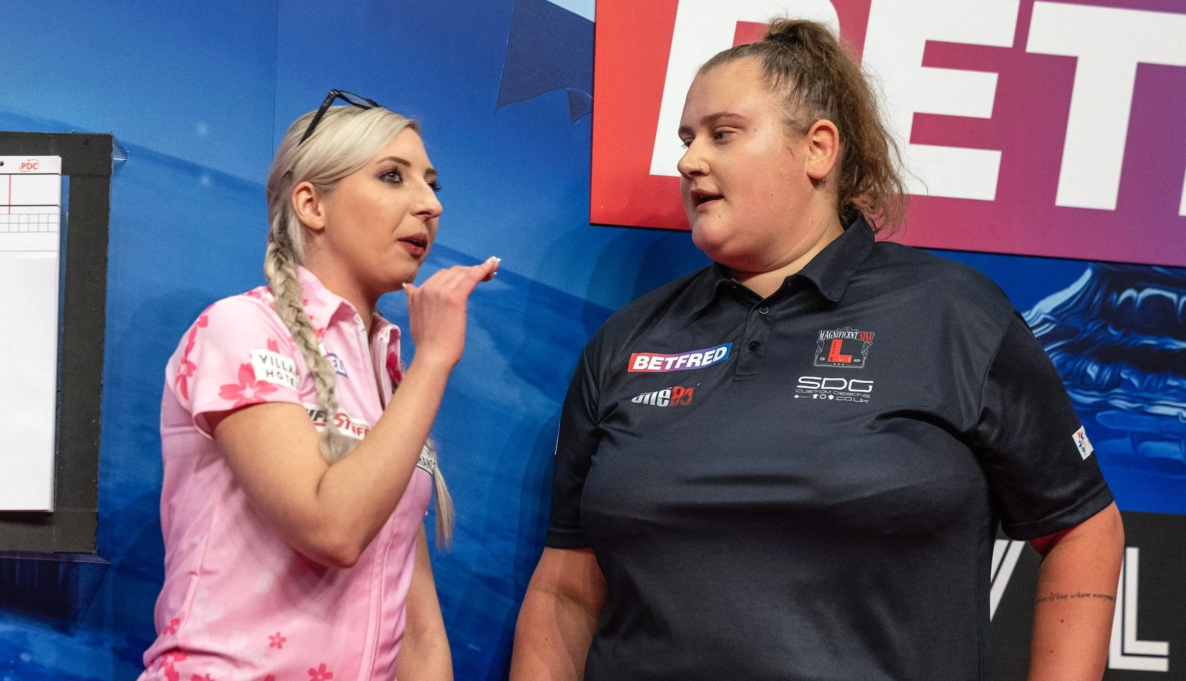 Fallon Sherrock and Beau Greaves talking to each other on stage