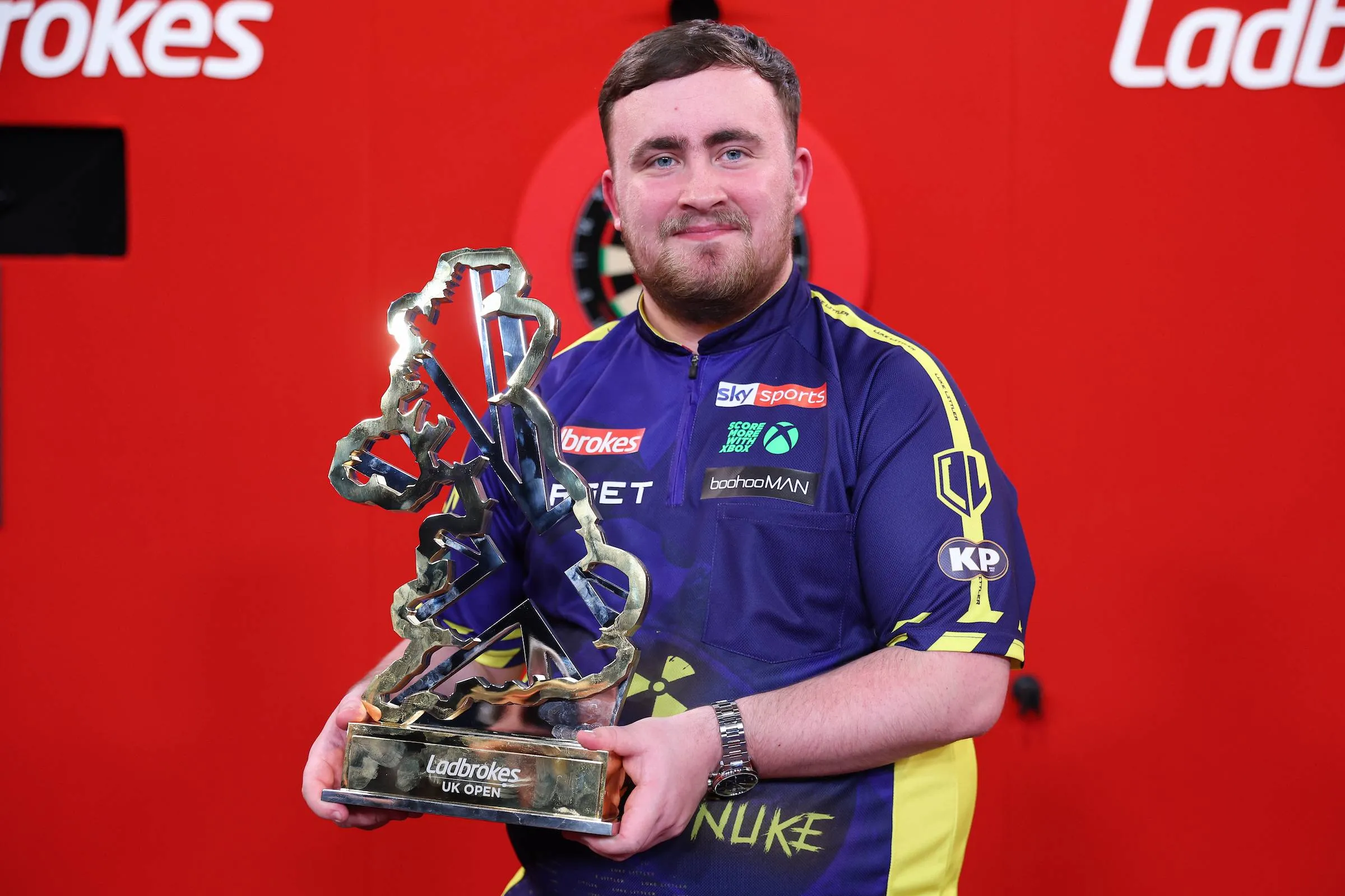 Luke Littler lifts the trophy