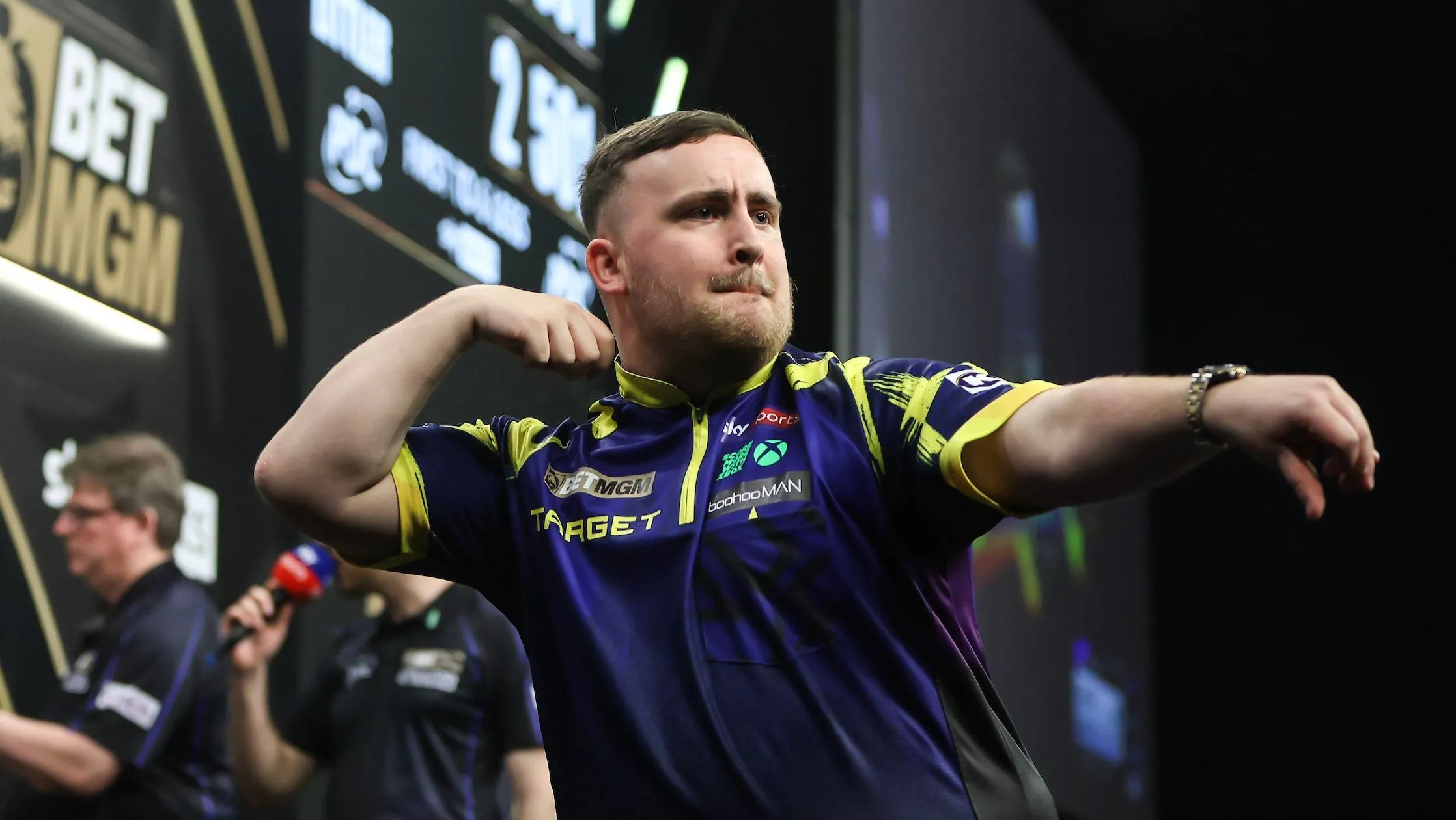 Luke Littler celebrates on stage