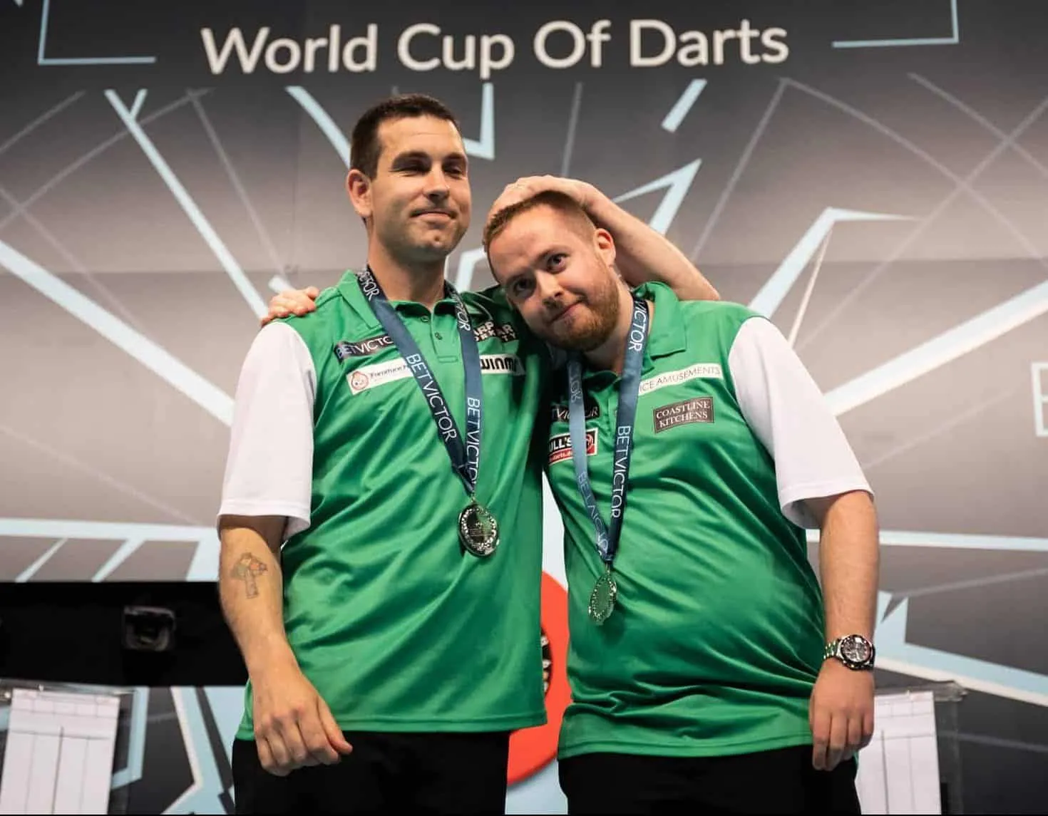 William O'Connor and Steve Lennon embrace on stage after the lost final at the World Cup of Darts in 2019.