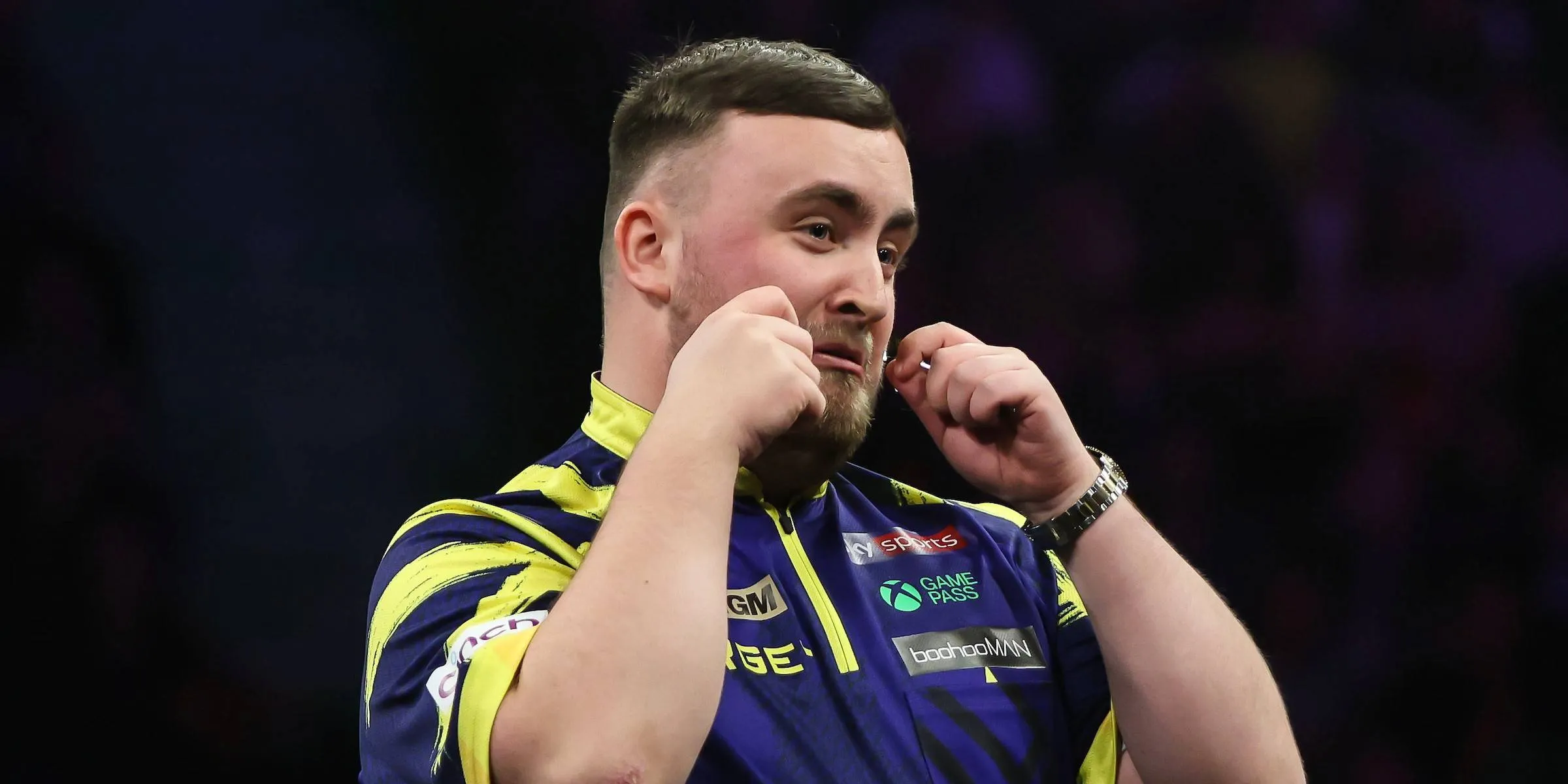 Luke Littler makes a crying gesture toward the crowd