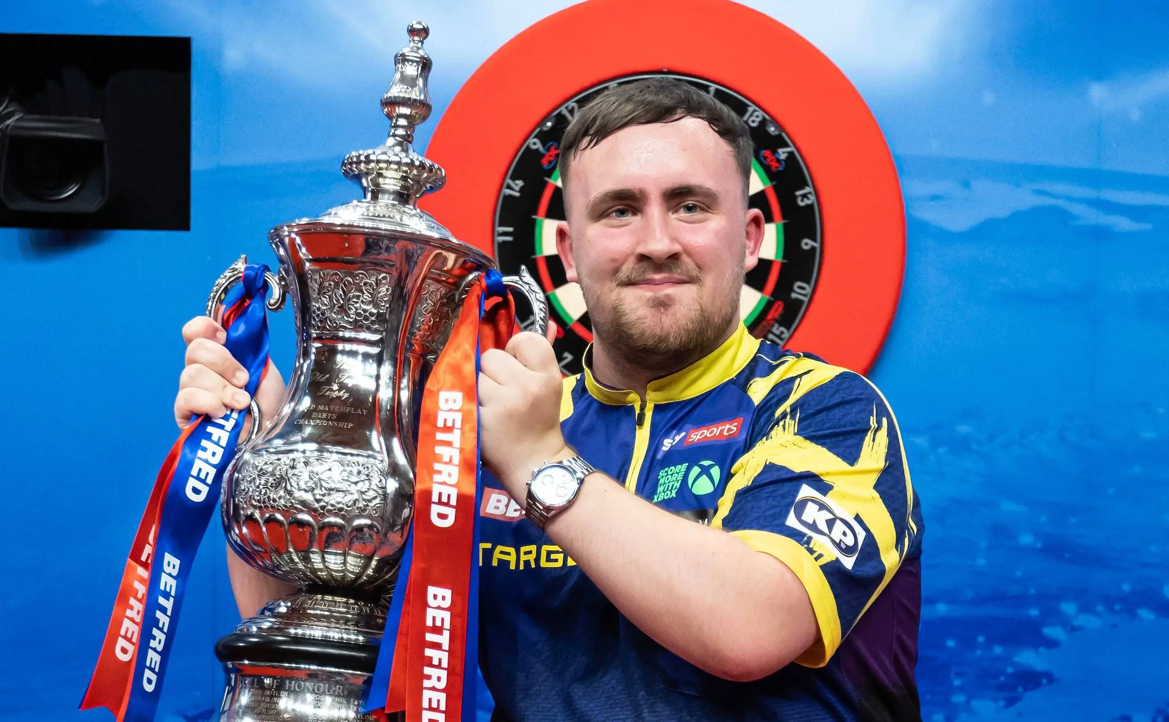 Luke Littler poses with the World Matchplay trophy