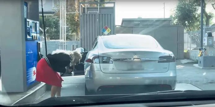 Vrouw onderneemt een dappere poging om een Tesla af te tanken