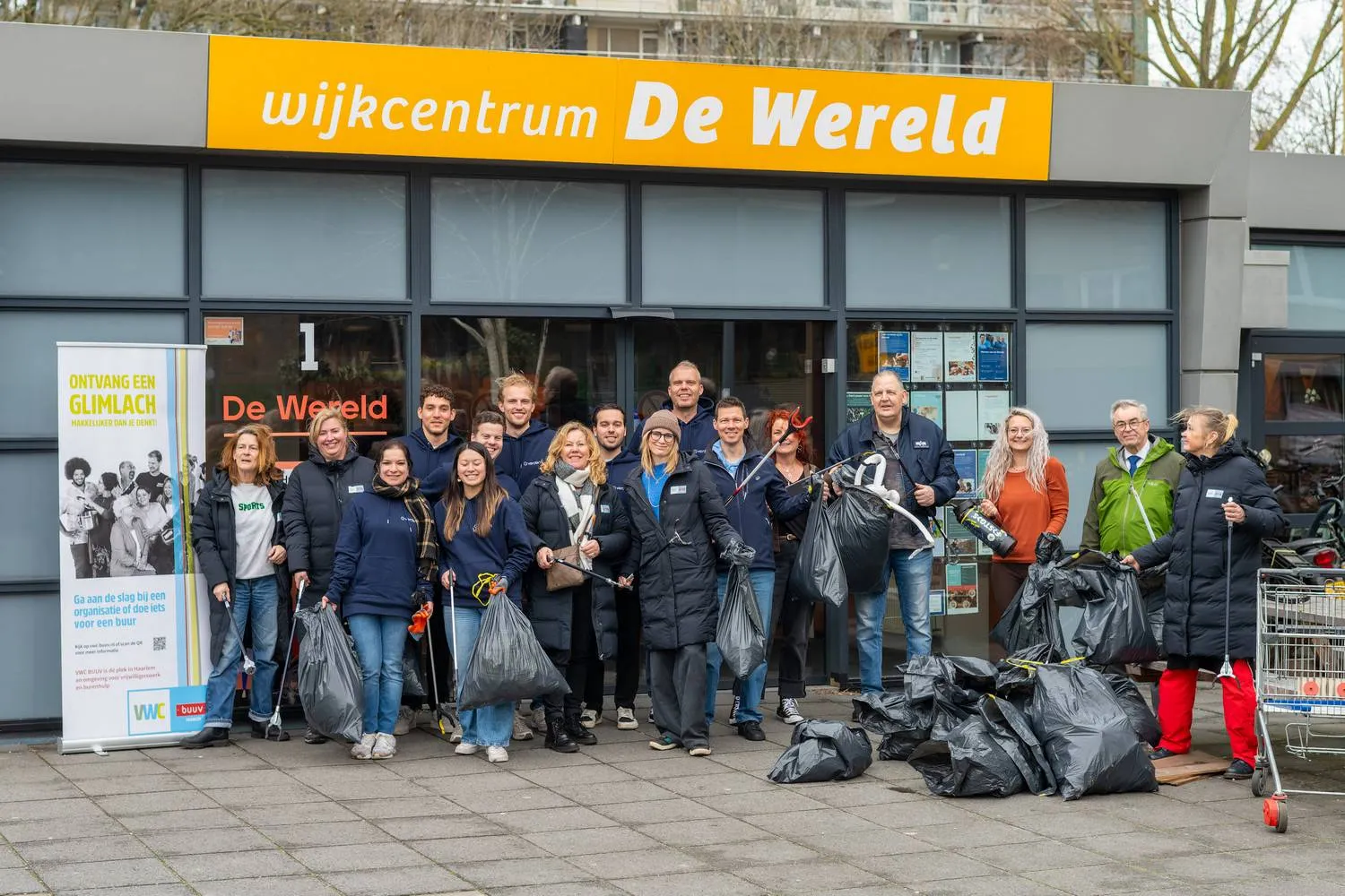 De schoonmaakploeg met het verzamelde afval bij Huis van de Wijk De Wereld