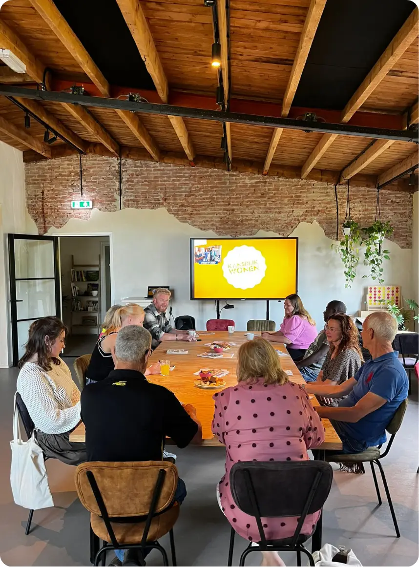 Mensen aan tafel tijdens een bijeenkomst van Kansrijk Wonen
