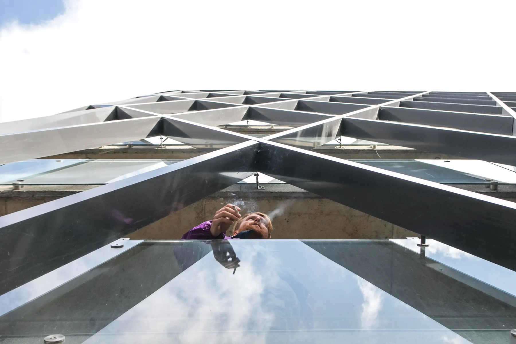 Balkone cigaretę rūkantis žmogus