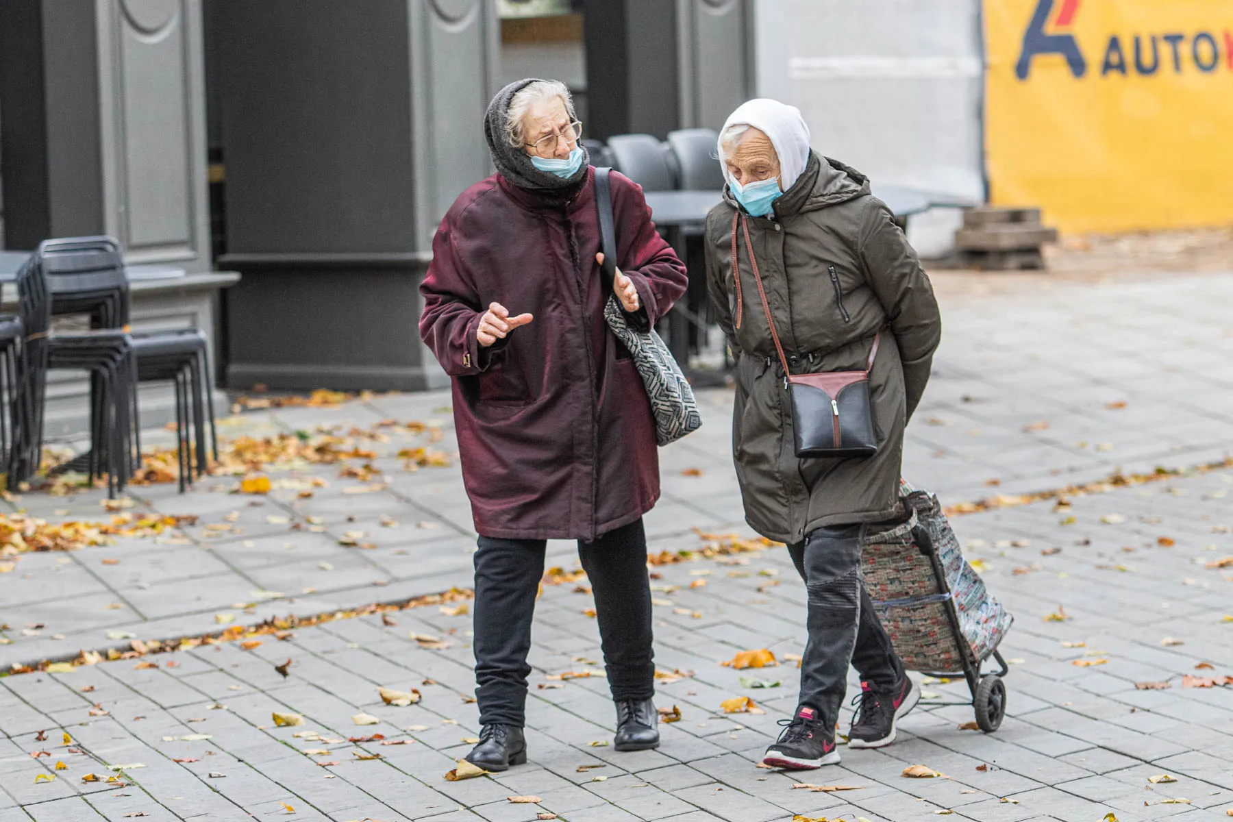 Žmonės su apsauginėm kaukėm