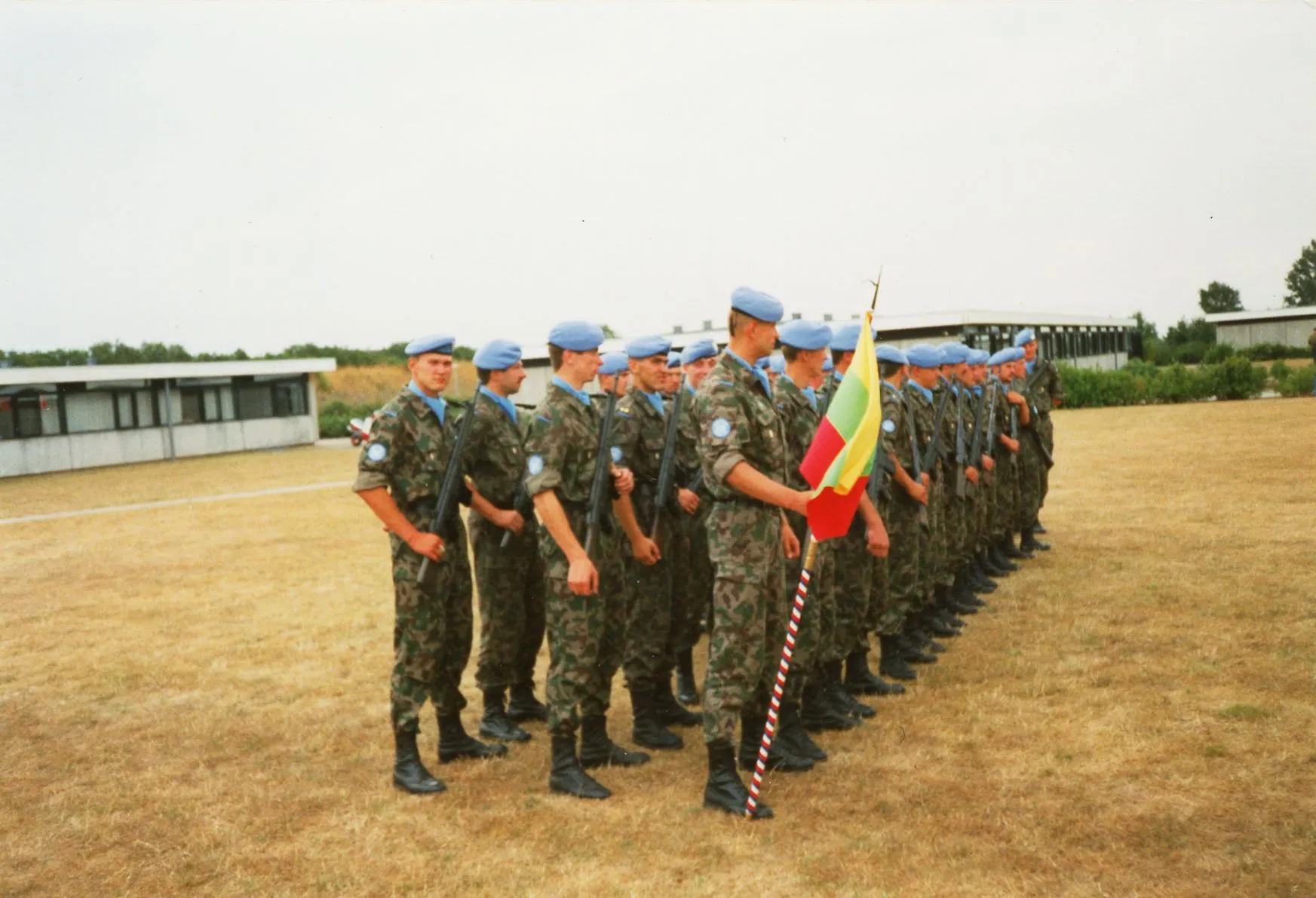 LITPLA-1 rikiuotėje su trispalve vėliava ir ginklais Kroatijoje, DANBAT (Danijos bataliono) sudėtyje. Trečioje eilėje, pirmas stovi ltn. Marius Kazlauskas, 1994 m.