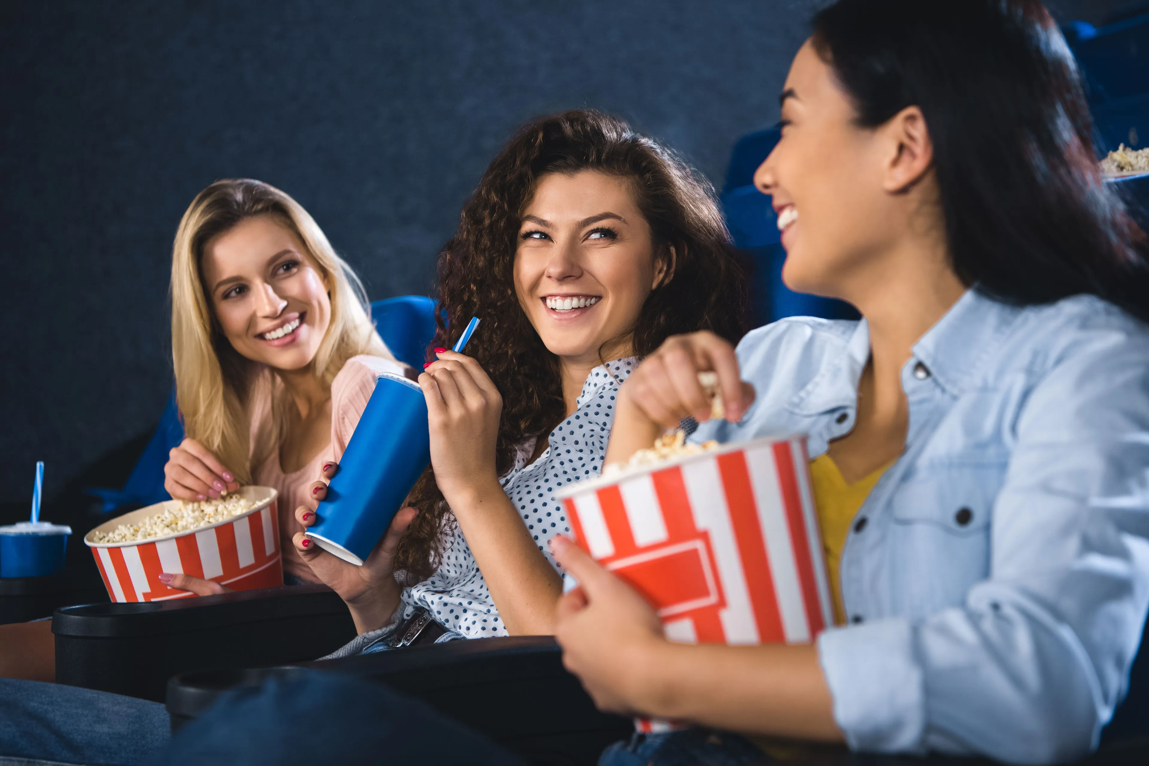 happy multiracial women with popcorn watching film 2023 11 27 05 19 37 utc