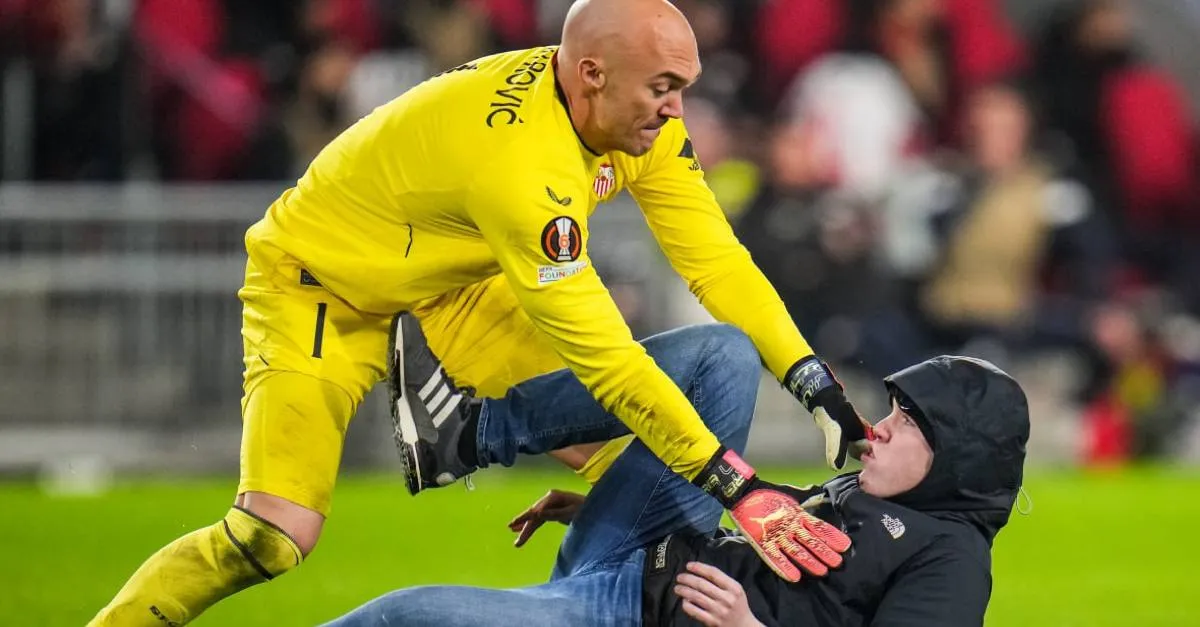 PSV-fan valt keeper van Sevilla op veld aan en wordt neergehaald (VIDEO)