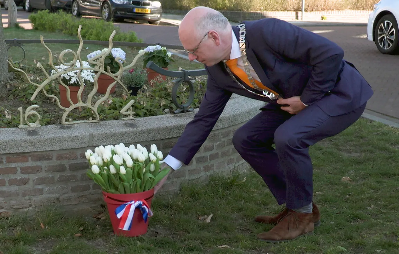 burgemeester legt bloemen peter van der ham