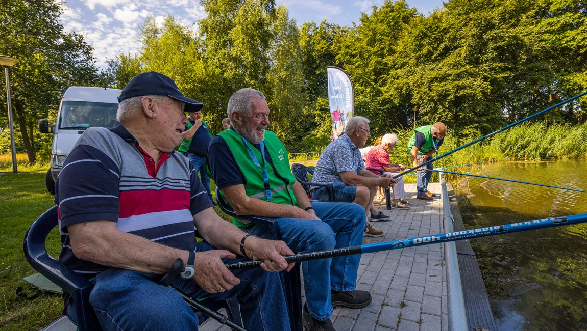 deelnemer en vrijwilliger lachen met overzicht visuitje