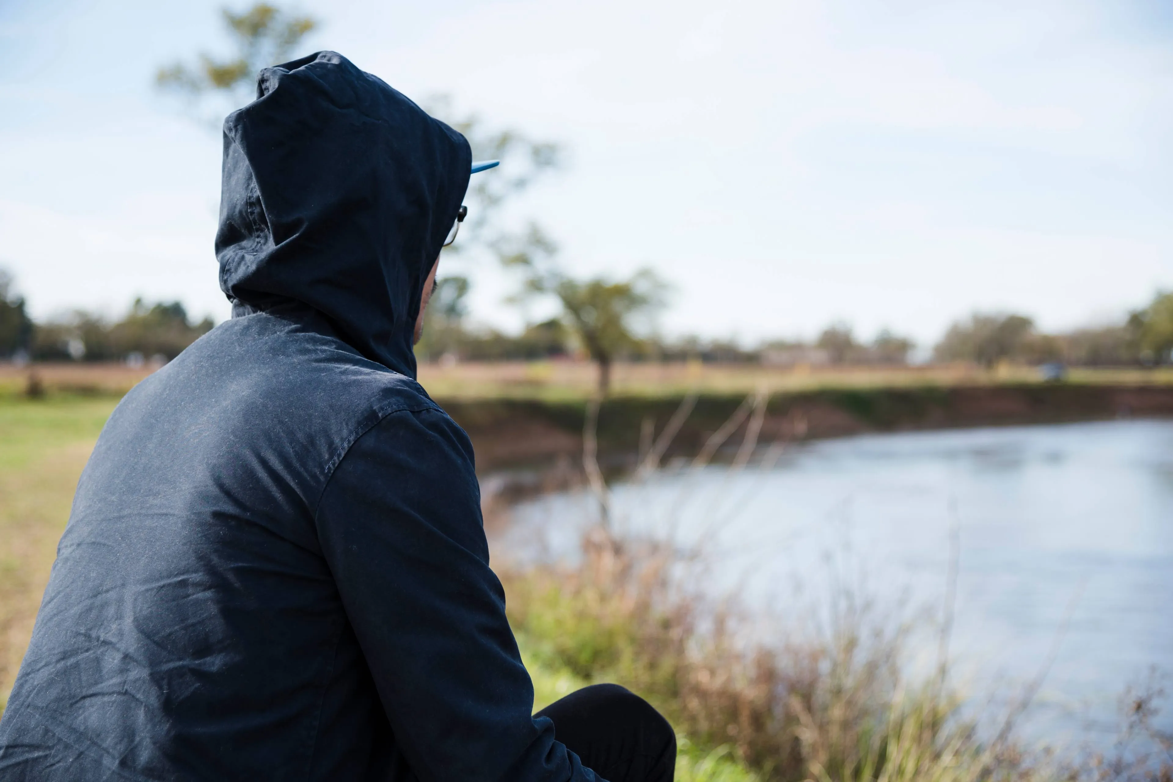 man-relaxing-by-lake-side-view