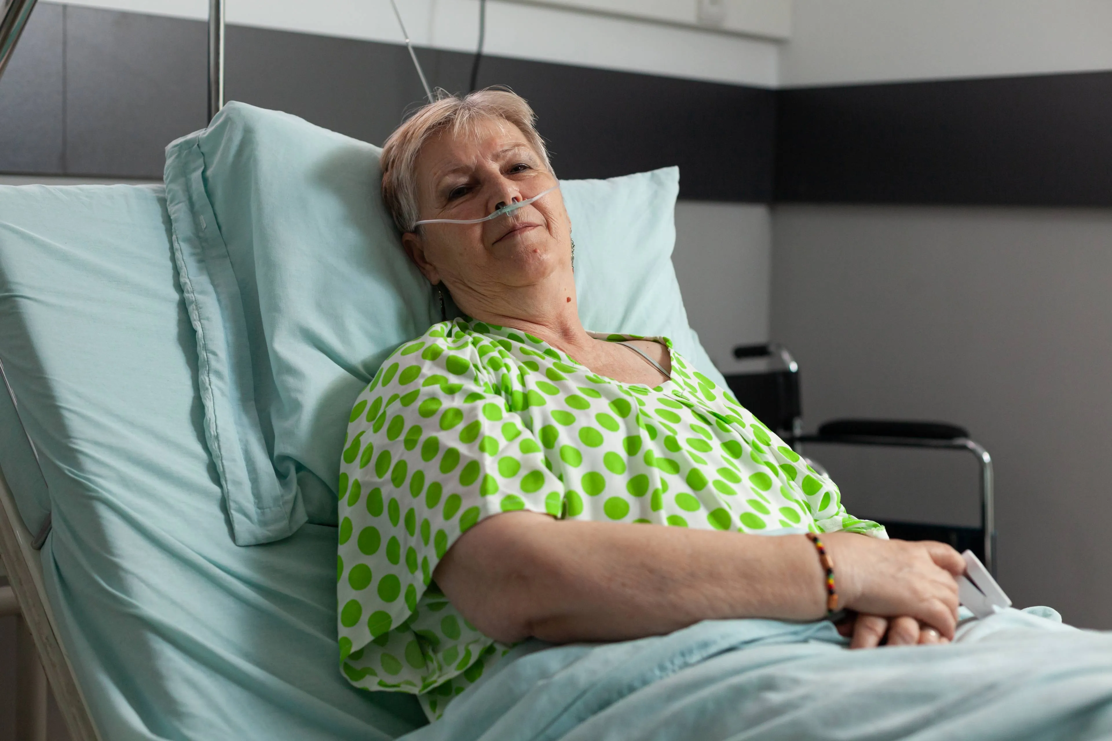 portrait-sick-pensioner-woman-looking-into-camera-while-resting-bed