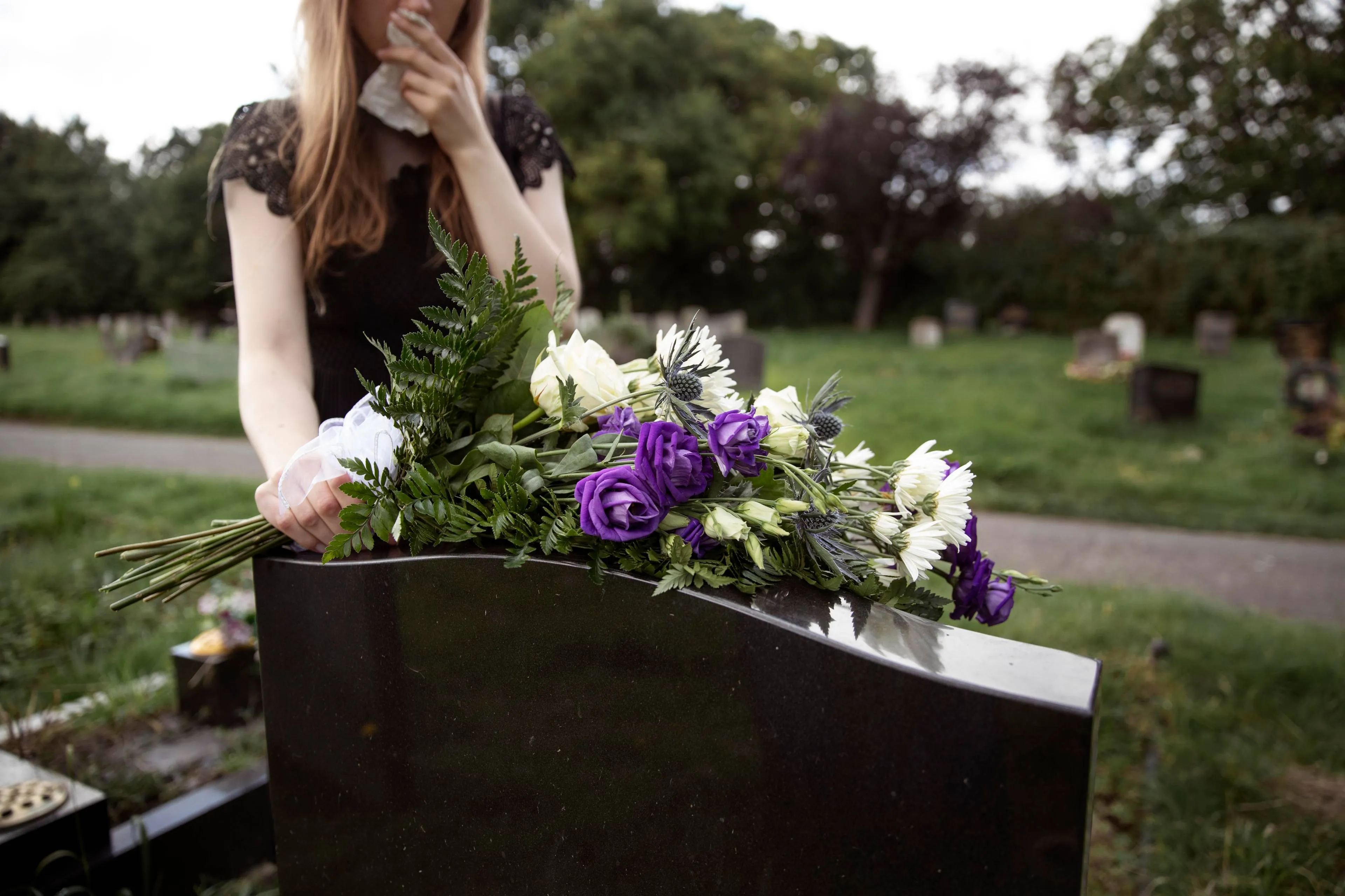 close-up-woman-visiting-grave-loved-one