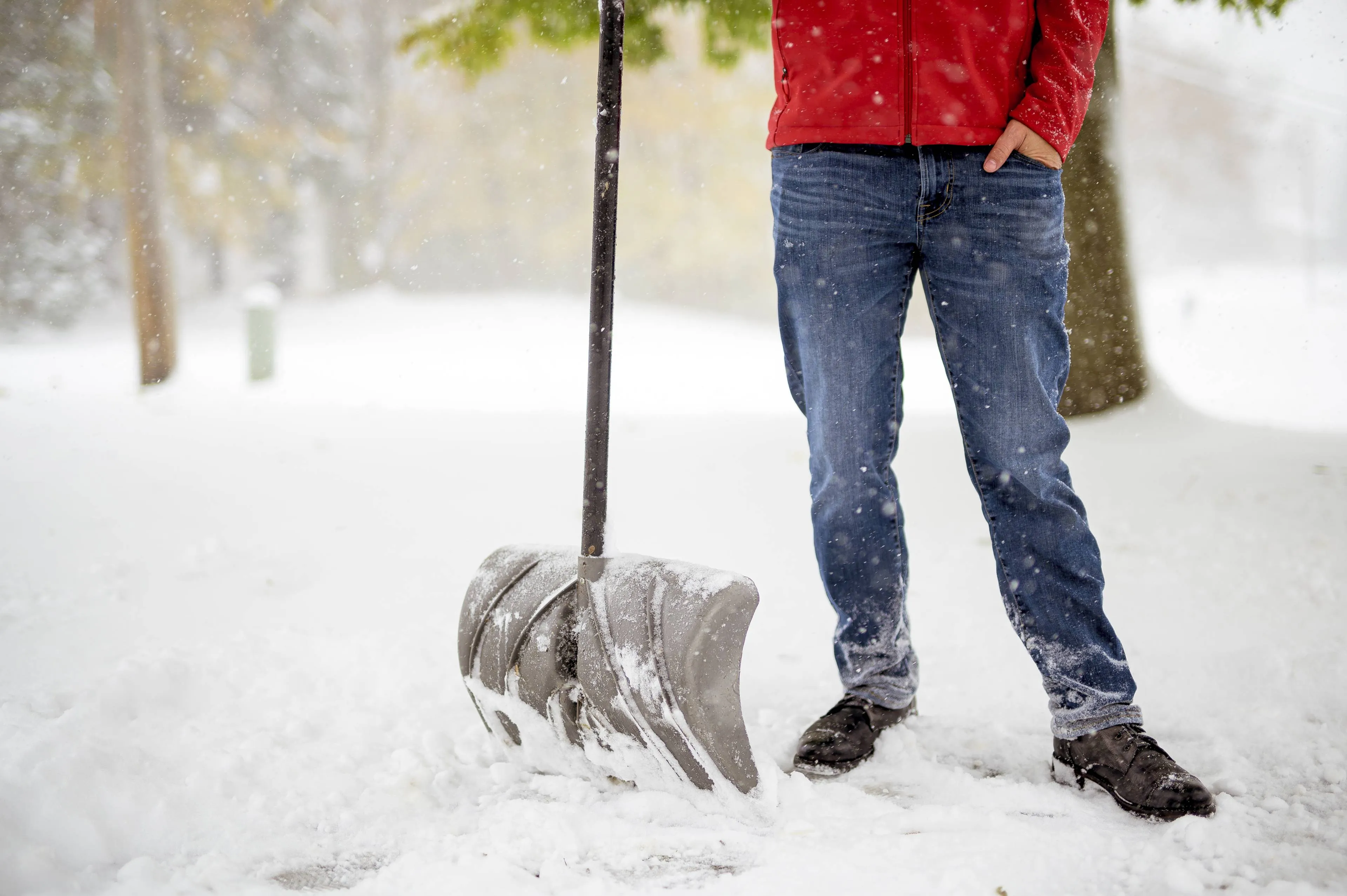 male-standing-snowy-field-holding-snow-shovel