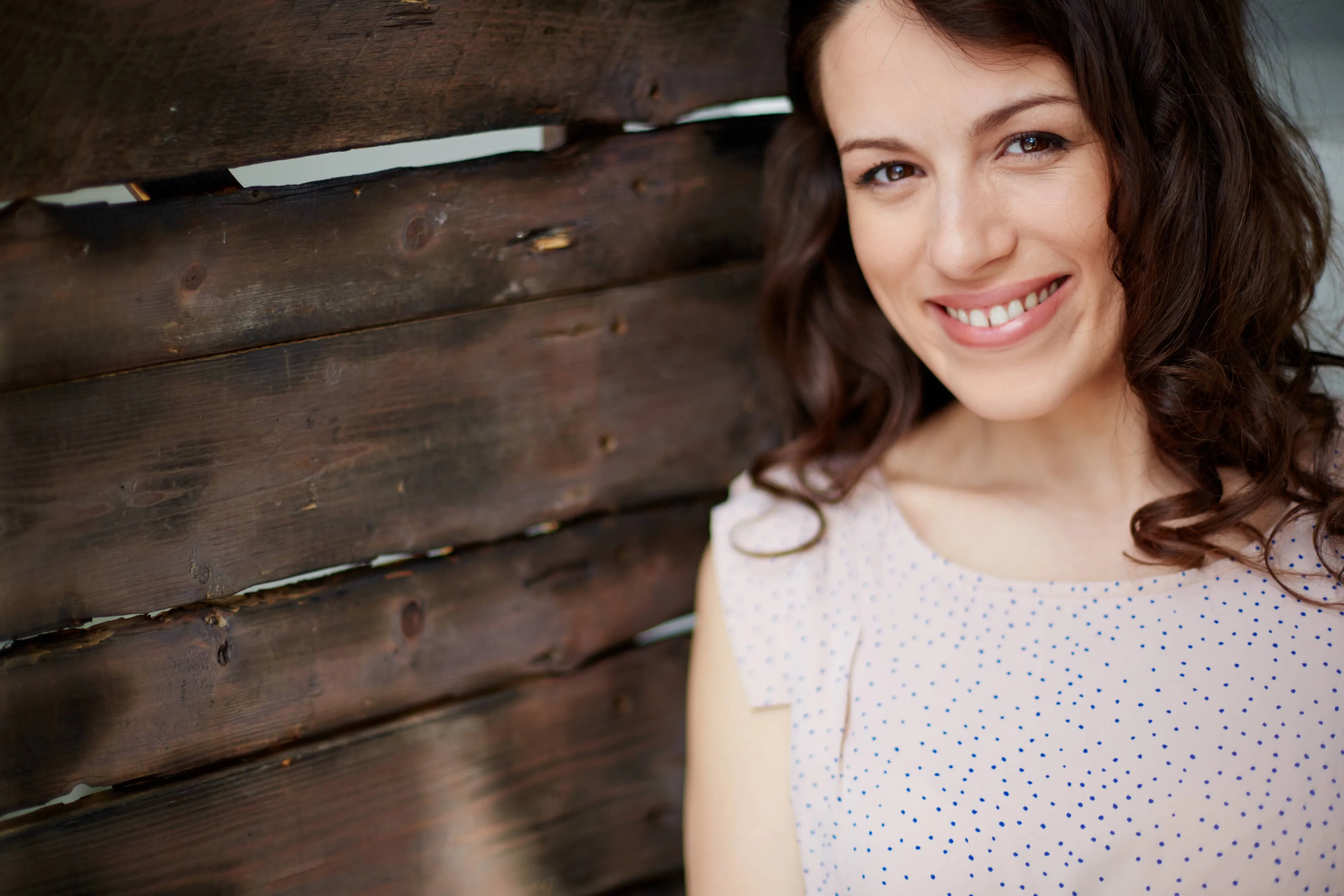 smiling-woman-with-wooden-background