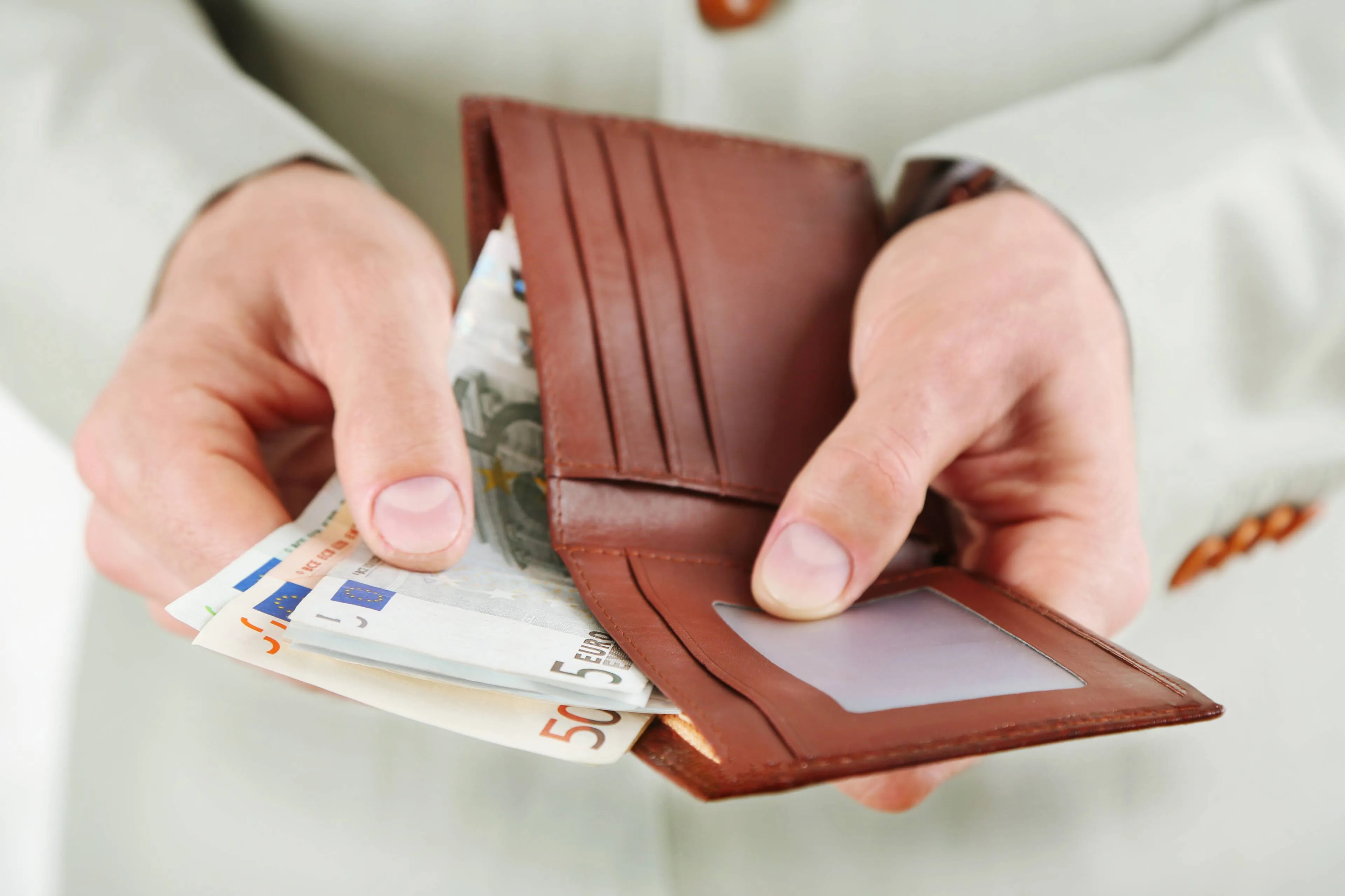 male-hands-holding-leather-wallet-with-euros-closeup
