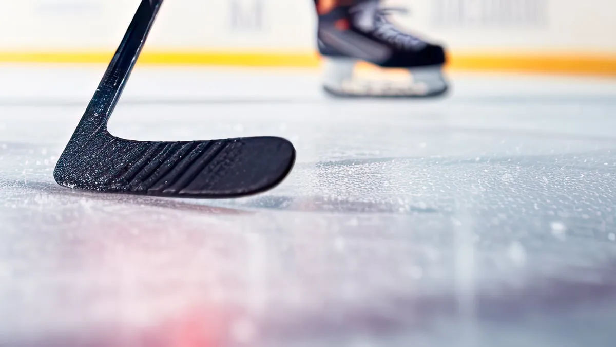 close up van ijshockey stick op ijsbaan in positie om hockey puck te raken