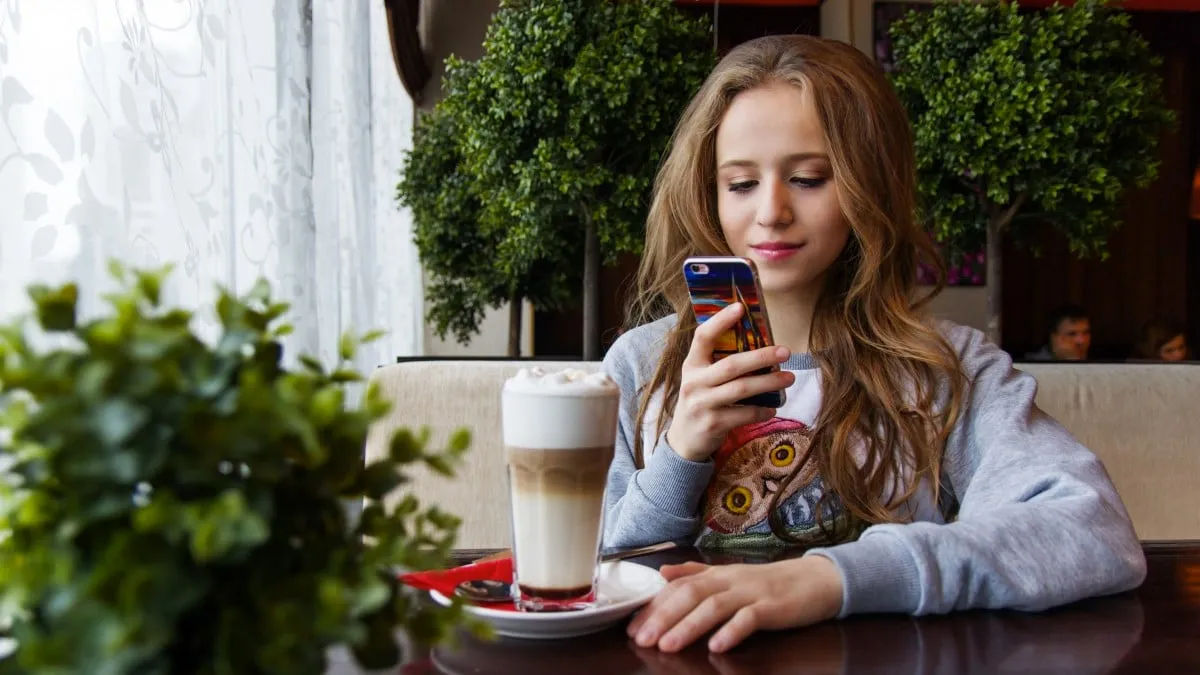 meisje smartphone coffee latte