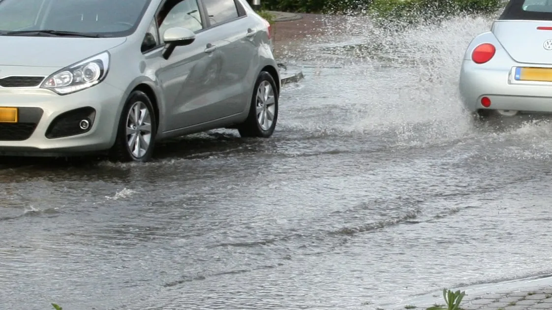 ondergelopen straat wateroverlast na hevige regenval tom bloem