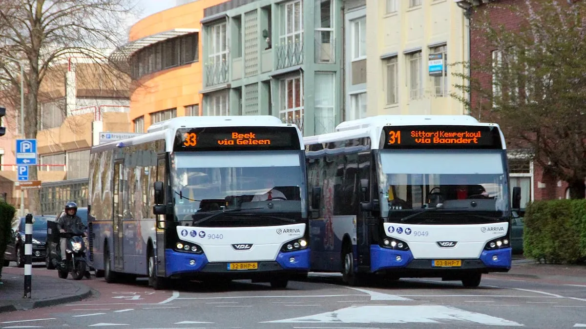 twee bussen van arriva naast elkaar voor het verkeerslicht