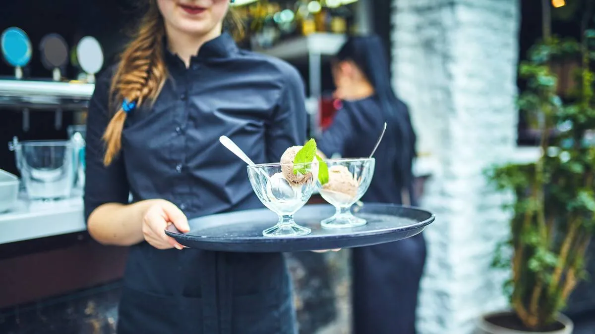 horeca serveerster brengt ijscoupes
