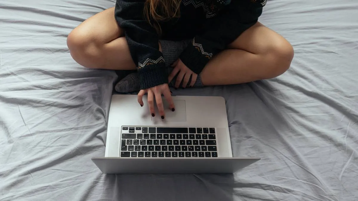 vrouw met laptop op bed