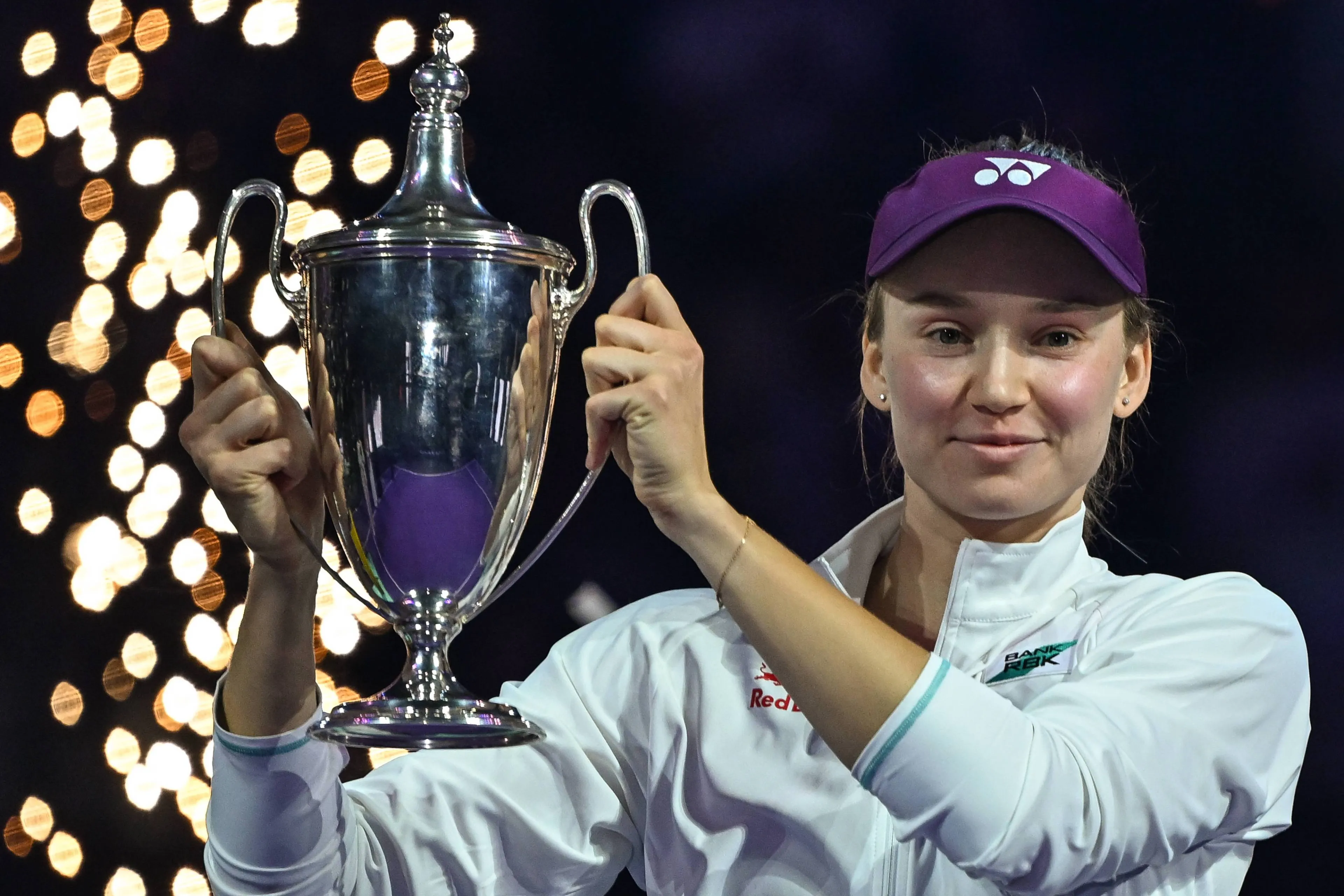 Elena Rybakina celebrates winning WTA Finals trophy.