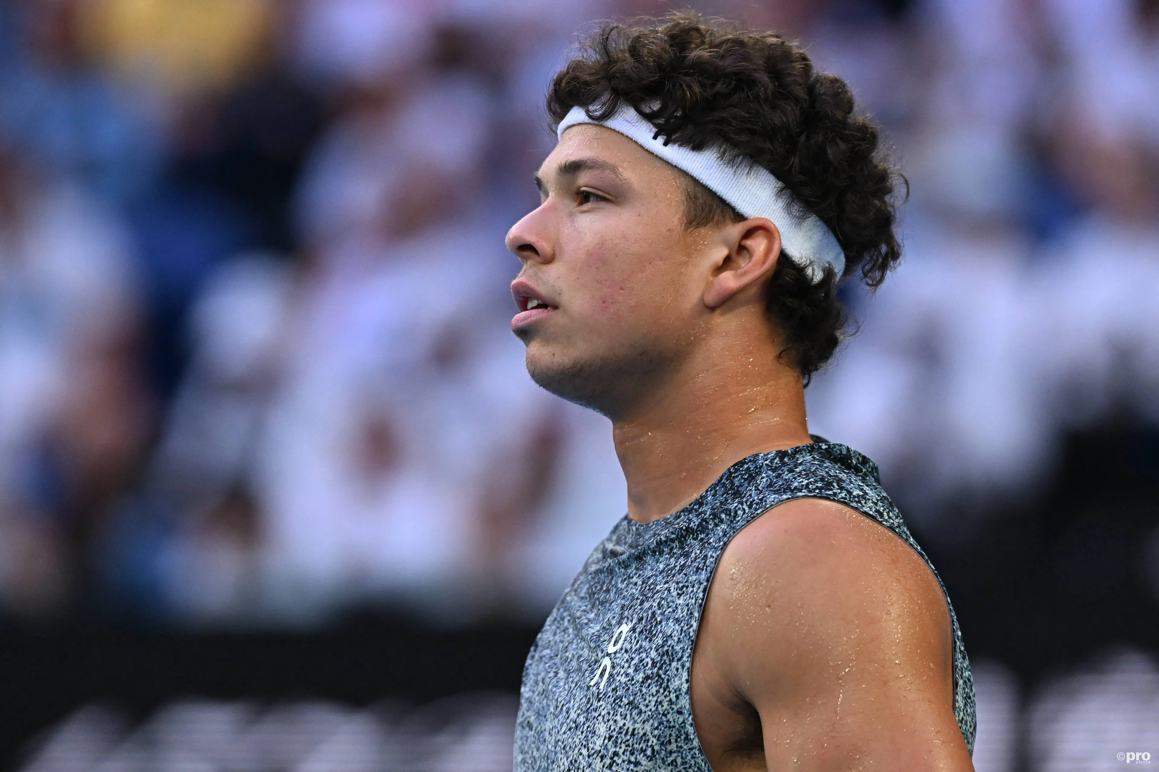 Ben Shelton looks on.