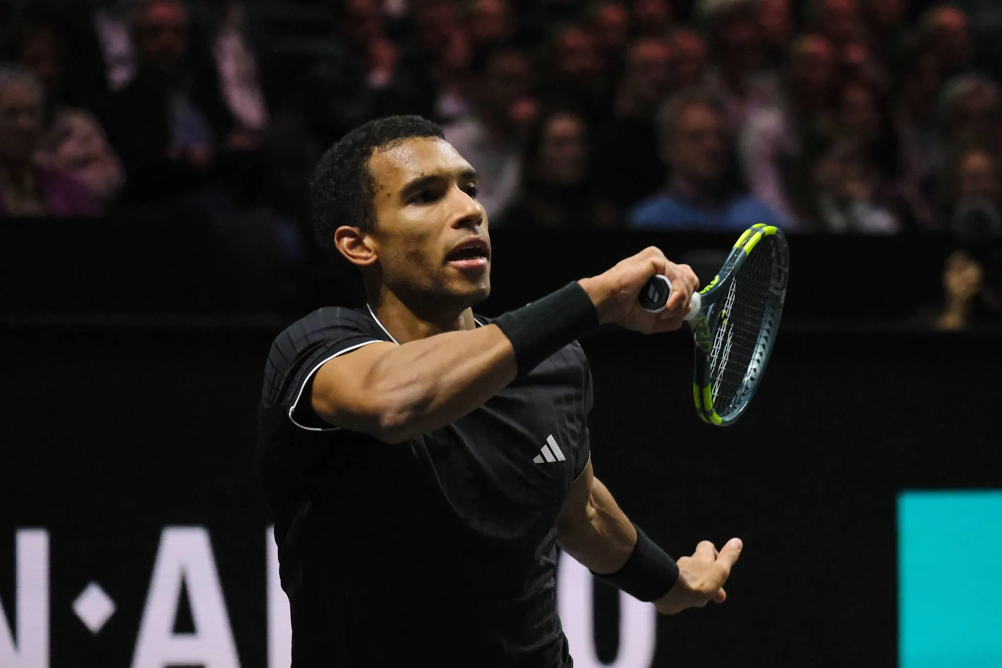 Felix Auger-Aliassime hits return.