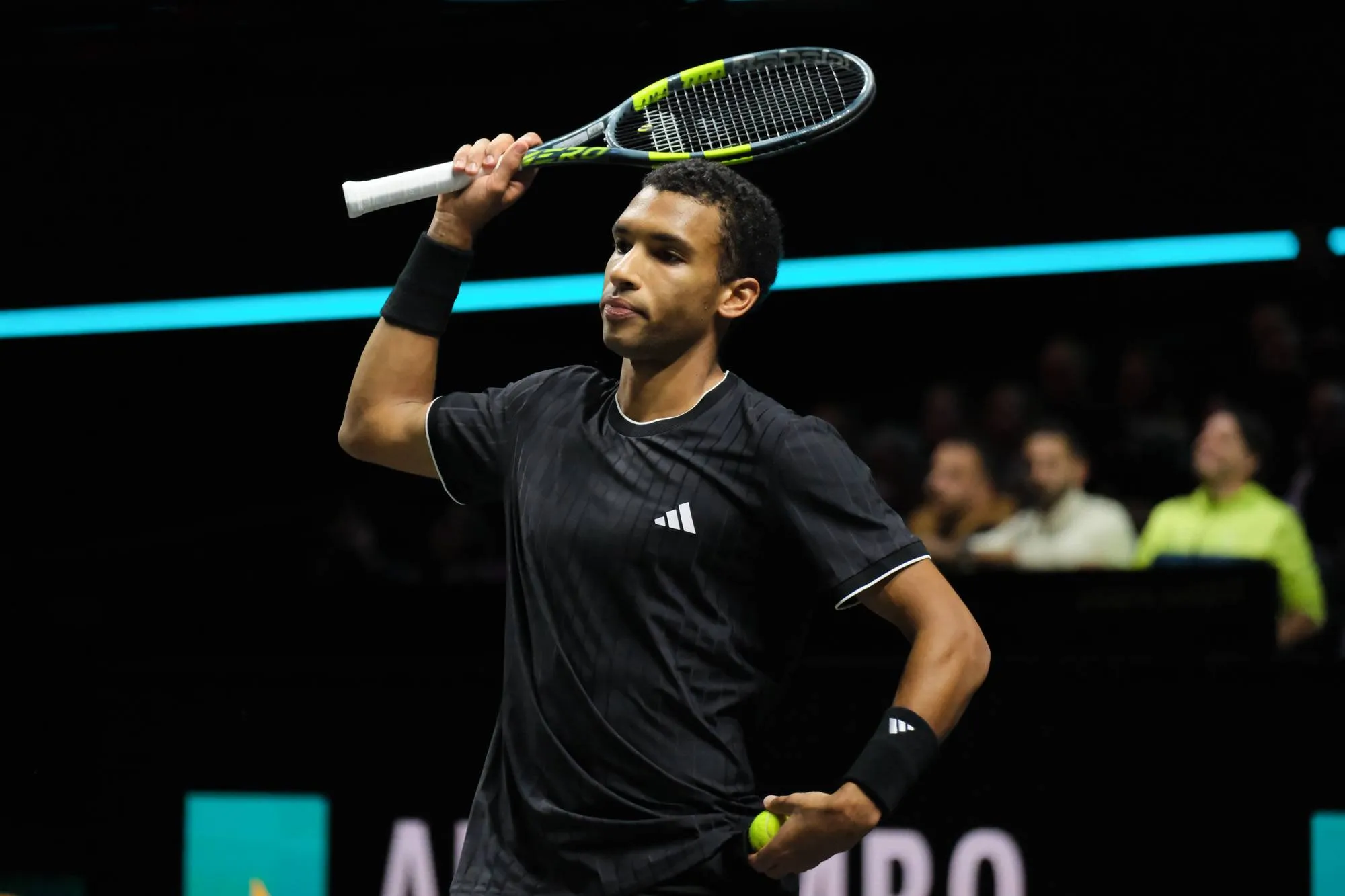 Felix Auger-Aliassime lifts racquet.