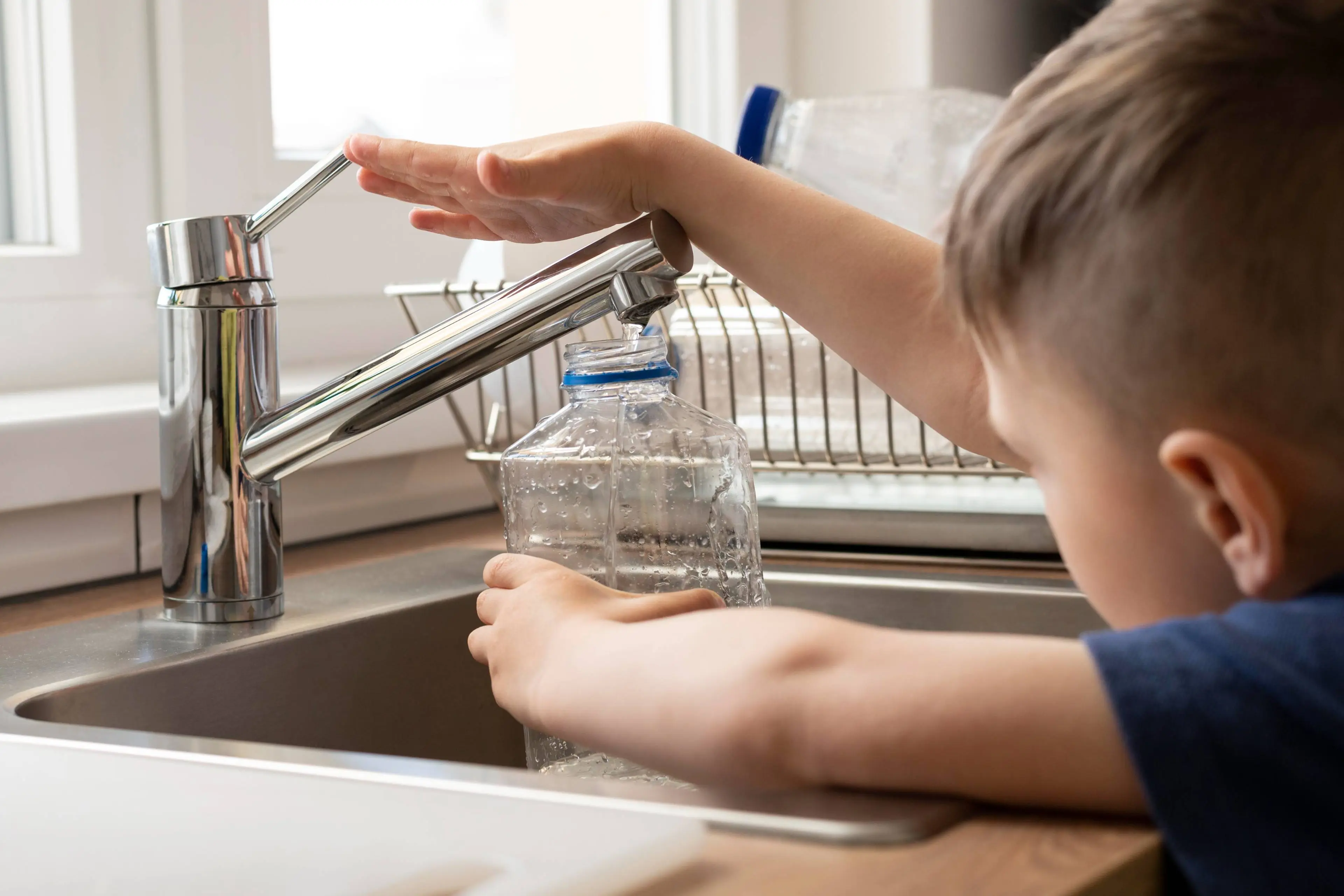 close-up-kid-filling-bottle-with-water
