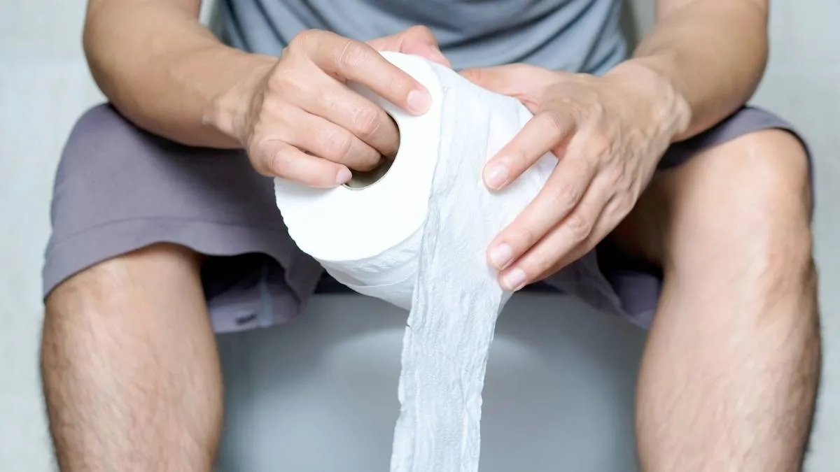 Mans-hands-holding-a-roll-of-toilet-paper