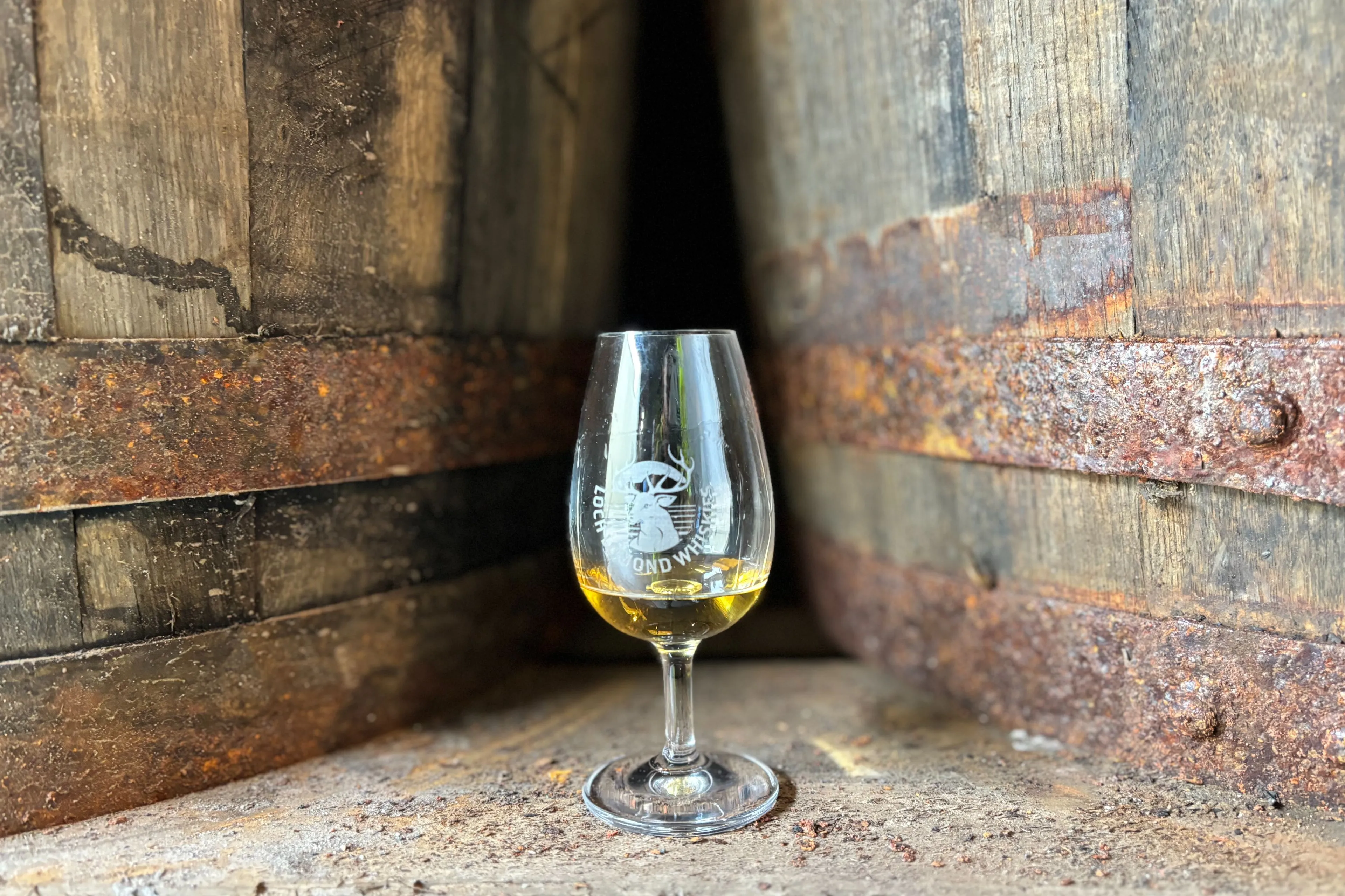 loch-lomond-glass-whisky in front of barrels