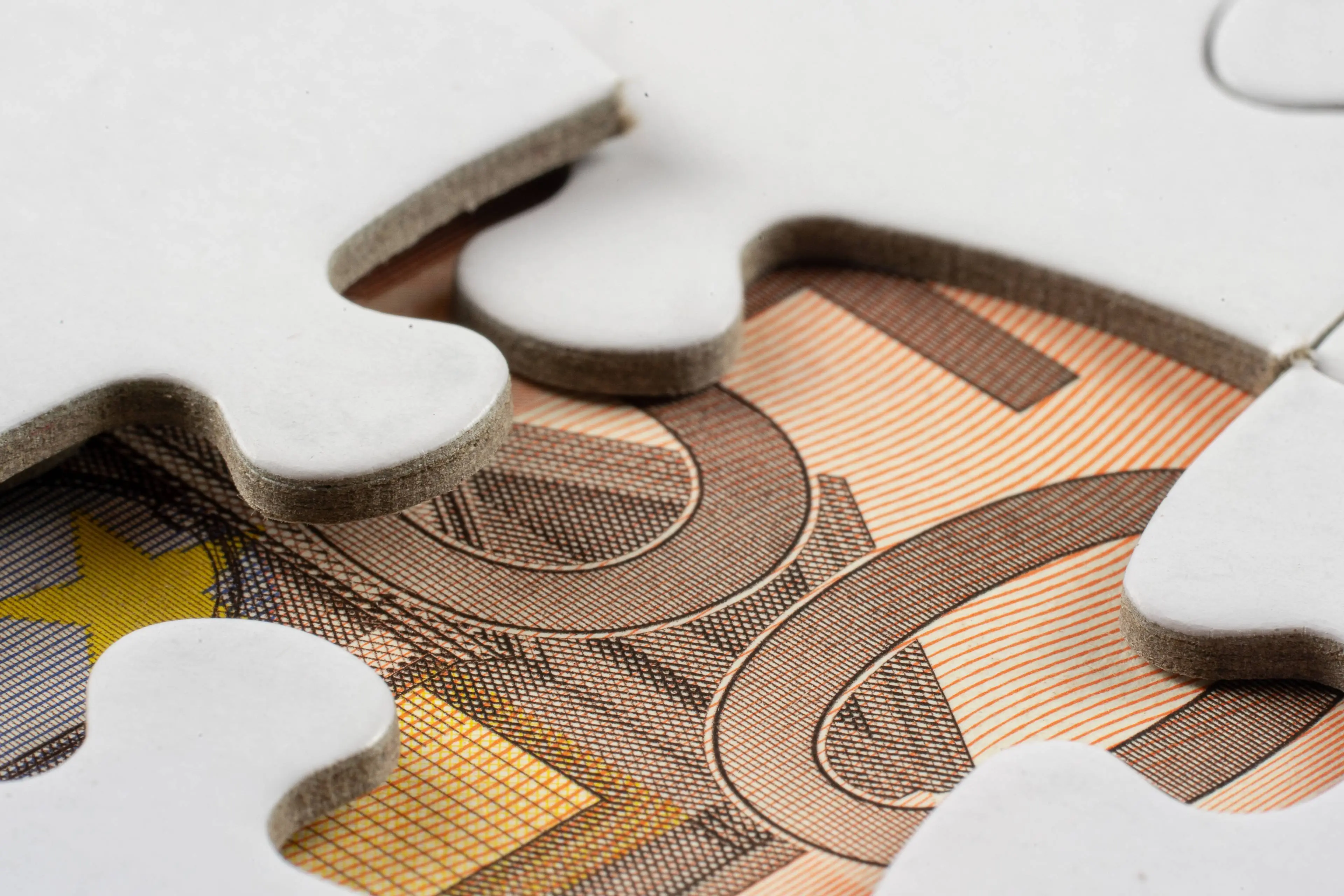 closeup-shot-part-money-seen-removed-piece-jigsaw-puzzle