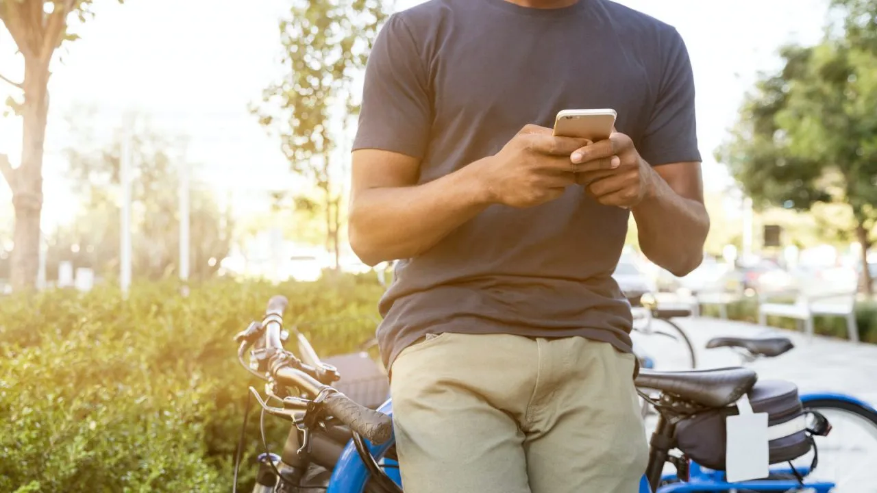 person leaning on bike while holding smartphone 1251855f1592402211