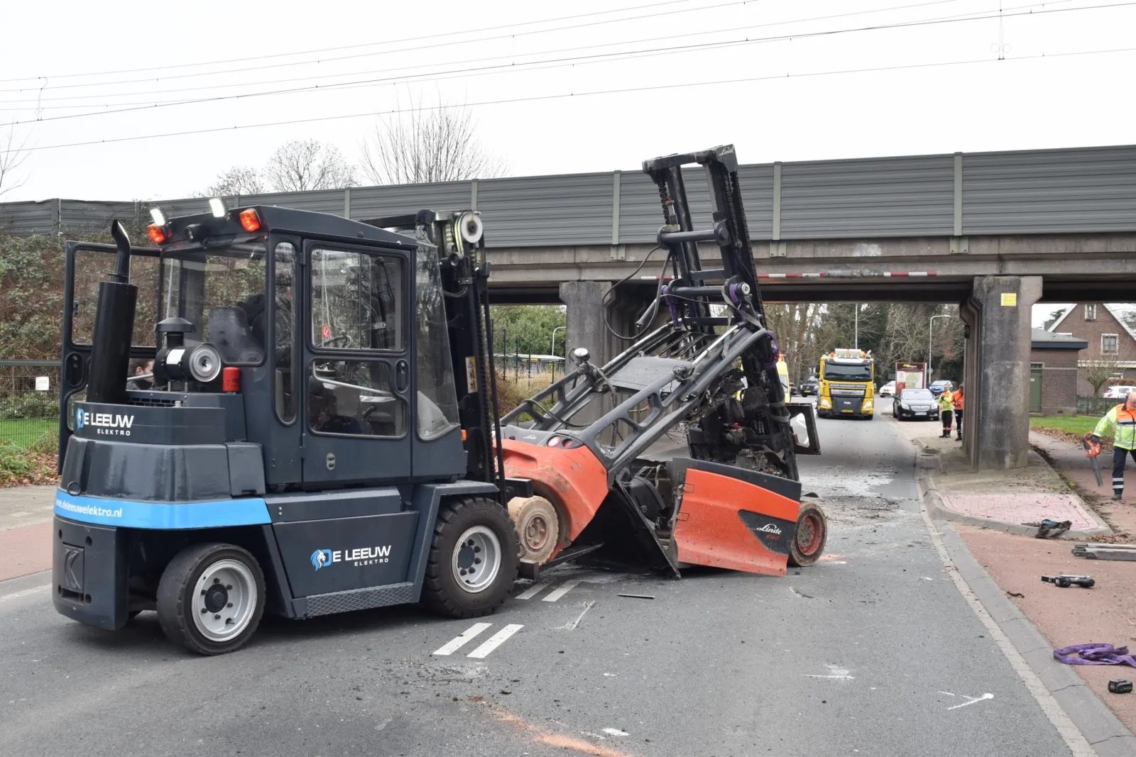 Heftruck valt van vrachtwagen na botsing met spoorviaduct in Waardenburg