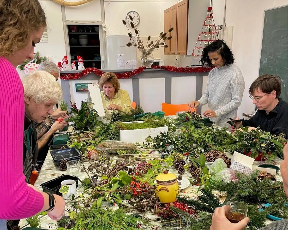 Onder begeleiding van vrijwiligers van Piëzo werden de mooiste kerststukjes gemaakt in Wijktuin Noordhove - foto Stichting Piëzo