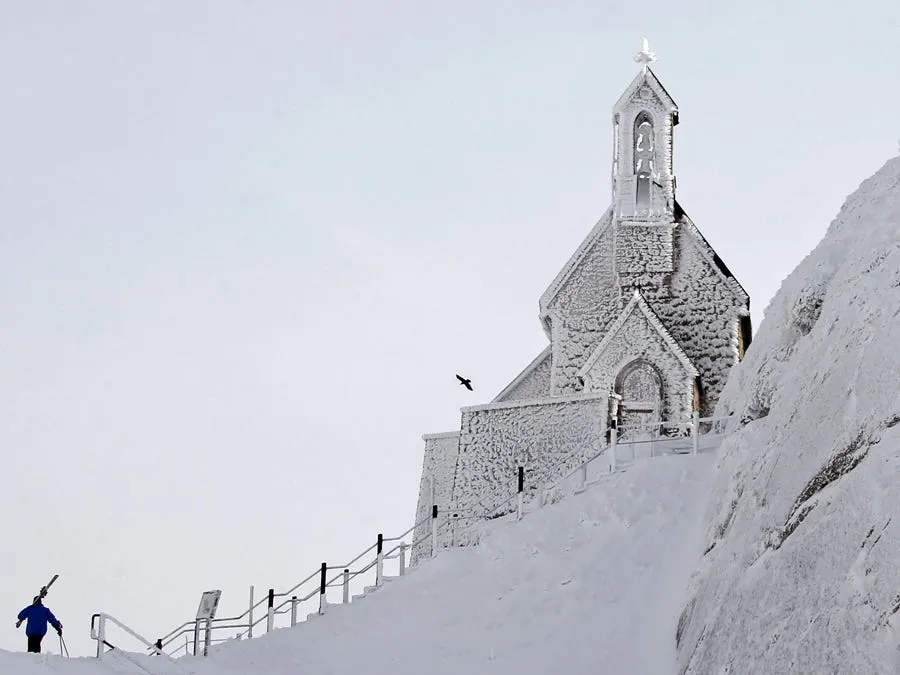 a skier makes his way near wendelstein church germanys highest church covered in snow