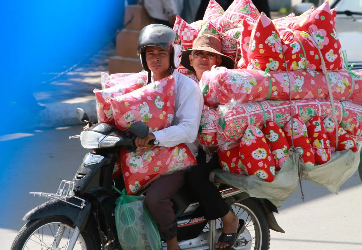 one moped two riders and lots of fluffy cushions in cambodia