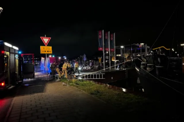 Omstanders helpen automobilist uit het water in Harderwijk