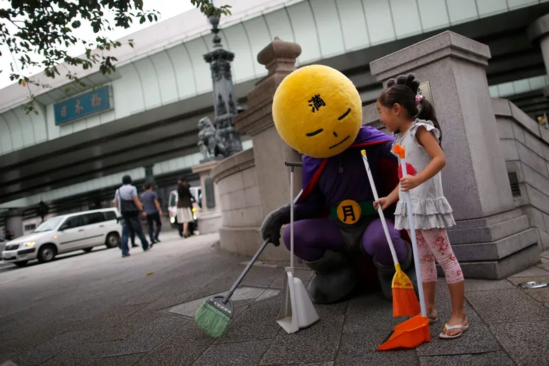this man who calls himself mangetsu man mr full moon identifies as a superhero and first appeared last year without any publicity or fanfare fighting garbage on the streets of tokyo his super weapons are a broom a dust pan and an army of volunteers